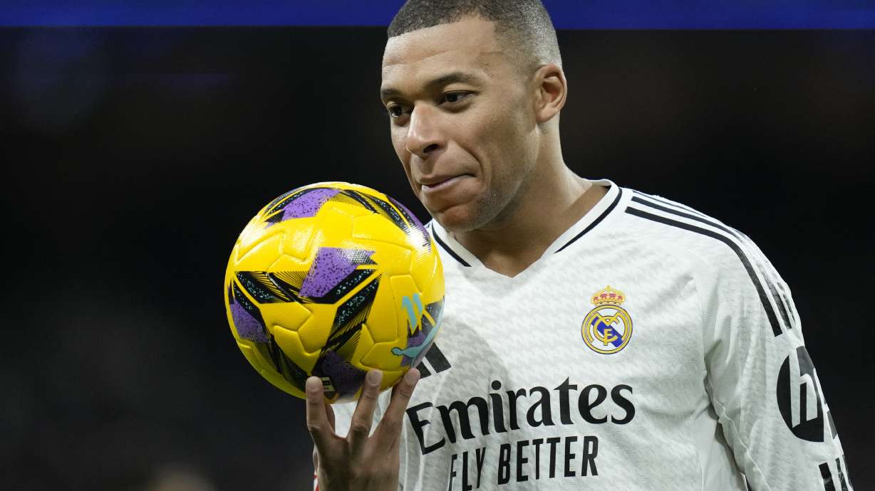 Real Madrid's Kylian Mbappe holds a ball during a Spanish La Liga soccer match against Las Palmas at the Santiago Bernabeu Stadium in Madrid, Spain, Sunday, Jan. 19, 2025.