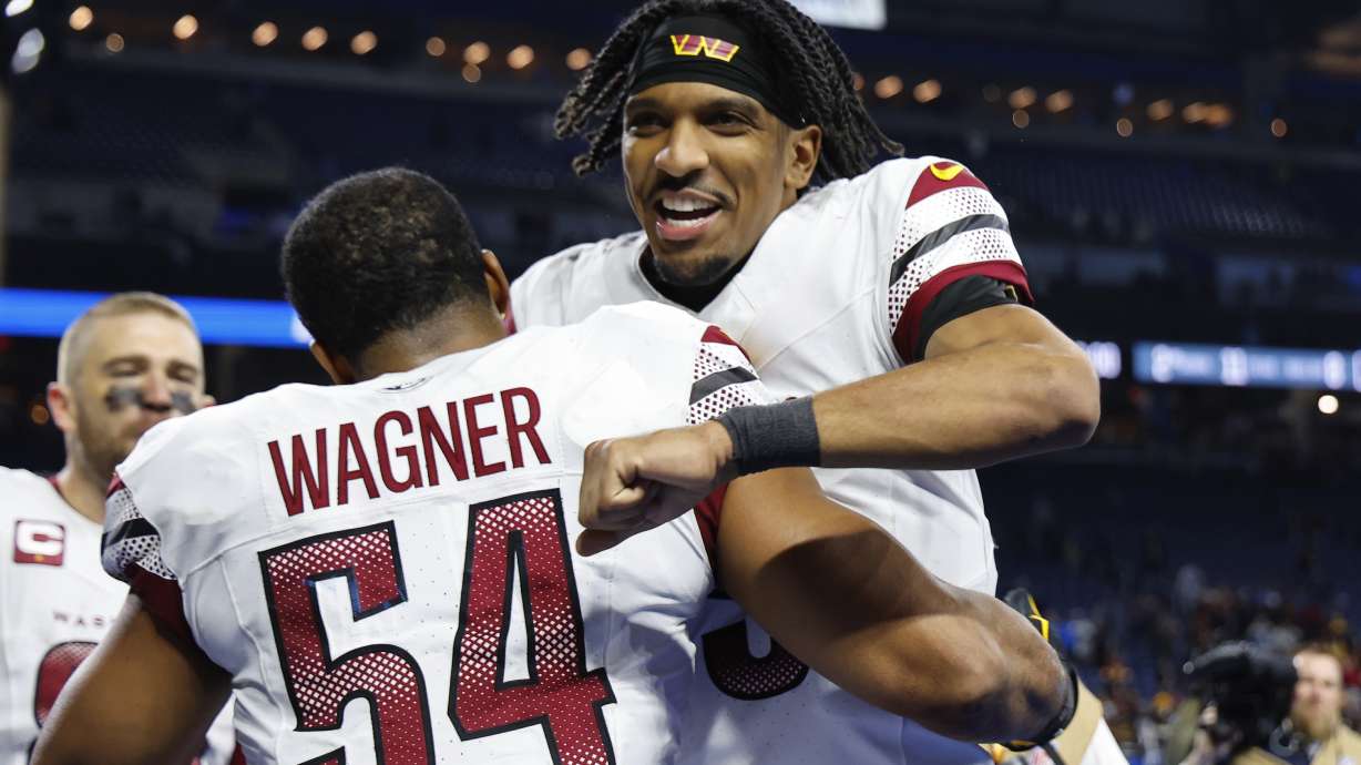 Washington Commanders quarterback Jayden Daniels celebrates with Bobby Wagner (54) after an NFL football divisional playoff game against the Detroit Lions, Saturday, Jan. 18, 2025, in Detroit.