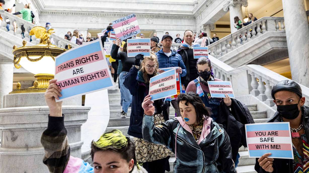 Demonstrators for transgender rights walk down the steps inside the rotunda at the state Capitol in Salt Lake City on Tuesday.