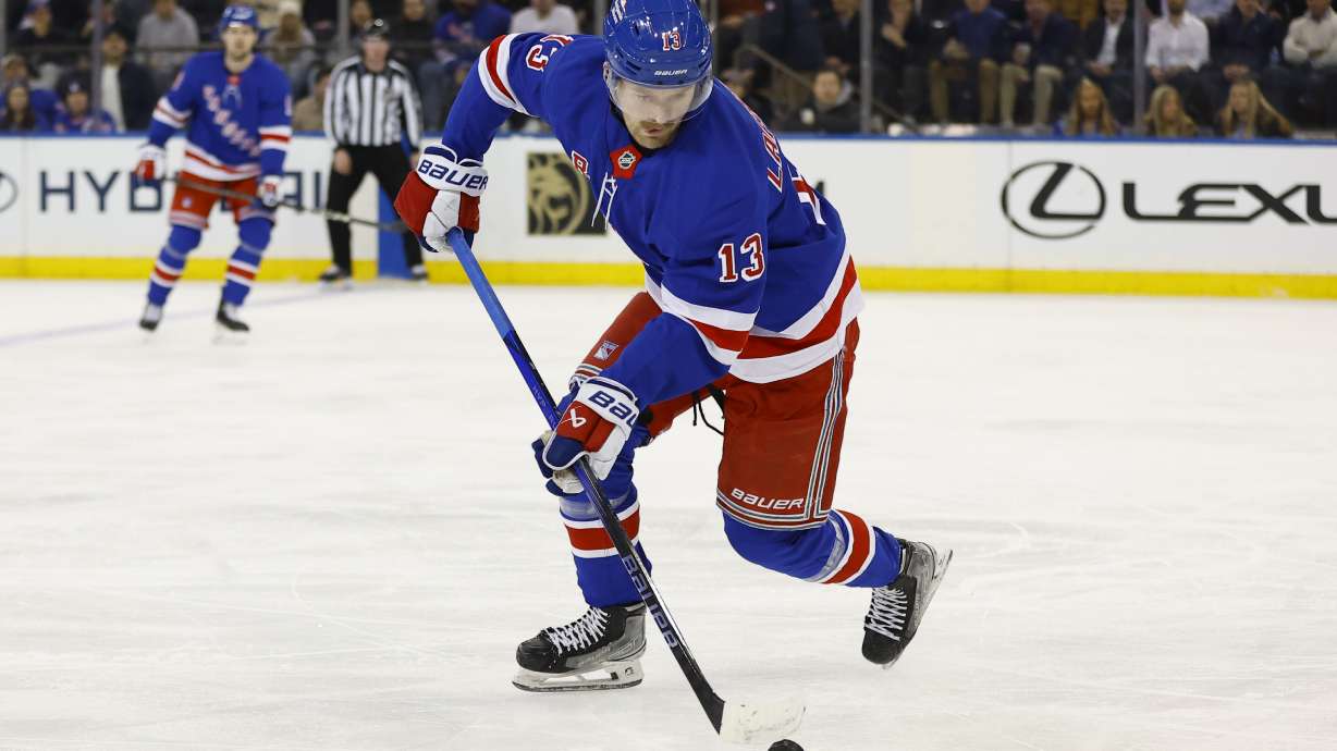 New York Rangers left wing Alexis Lafrenière (13) skates with the puck against the Ottawa Senators during the first period of an NHL hockey game, Tuesday, Jan. 21, 2025, in New York.