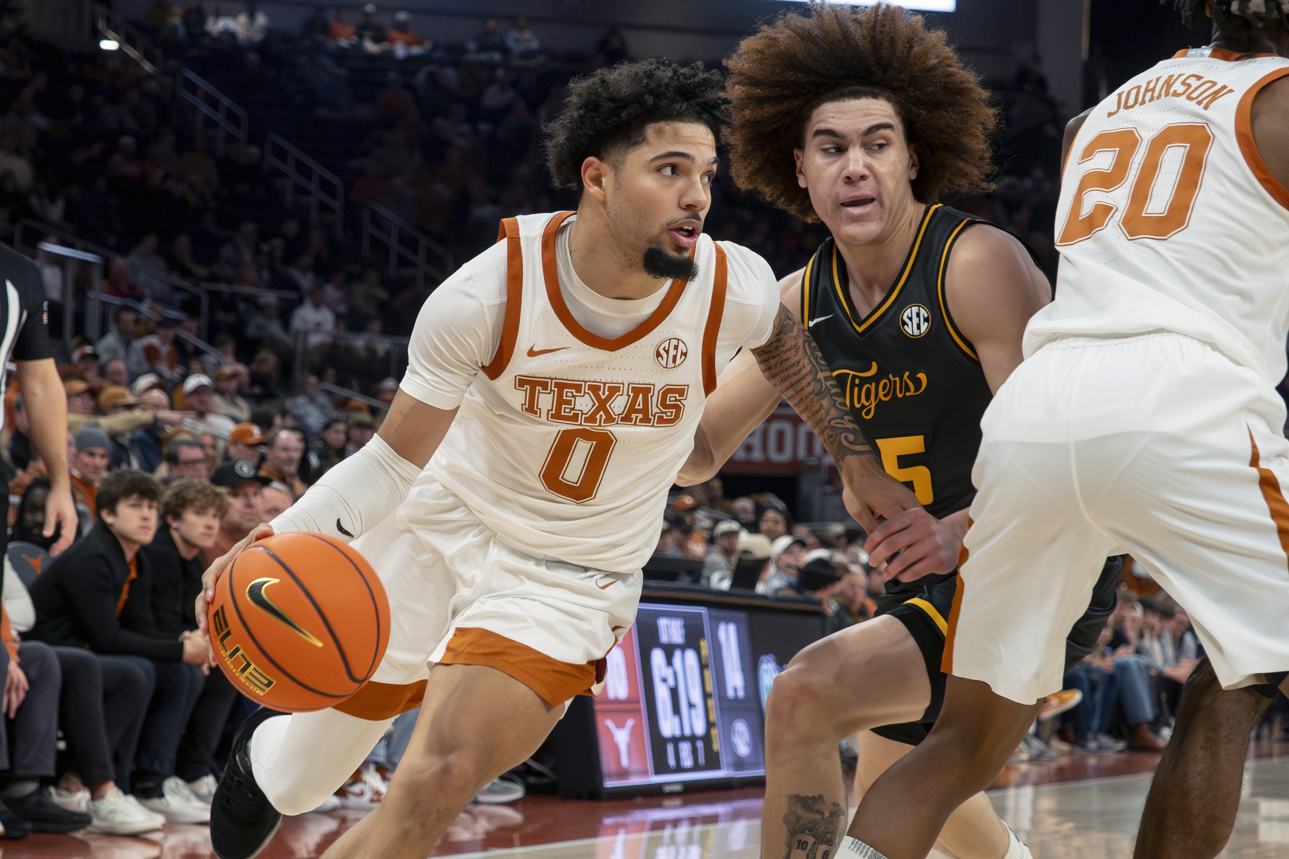 Texas guard Jordan Pope (0) dribbles the ball against Missouri guard T.O. Barrett (5) during the first half an NCAA college basketball game, Tuesday, Jan. 21, 2025, in Austin, Texas.