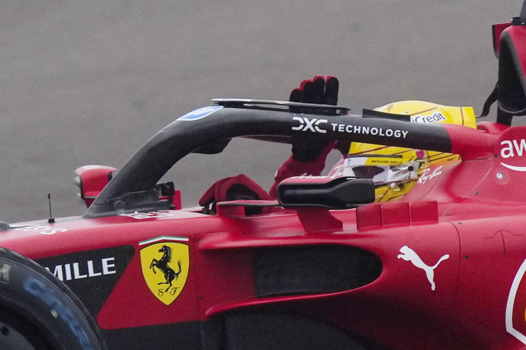 Lewis Hamilton waves to fans as he drives a Ferrari F1 car for the first time