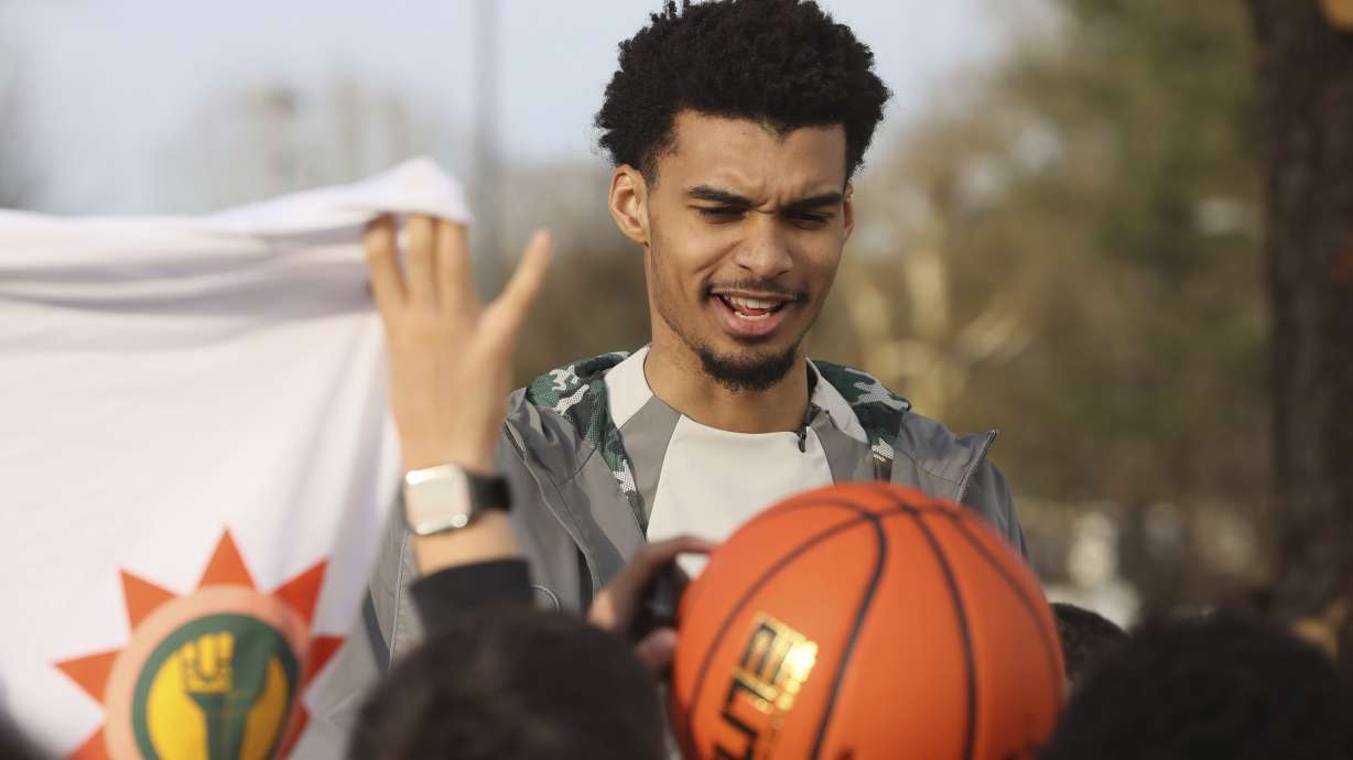 San Antonio Spurs' Victor Wembanyama reacts as he inaugurates a basketball court, Tuesday, Jan. 21, 2025 in Le Chesnay-Rocquencourt, south of Paris.