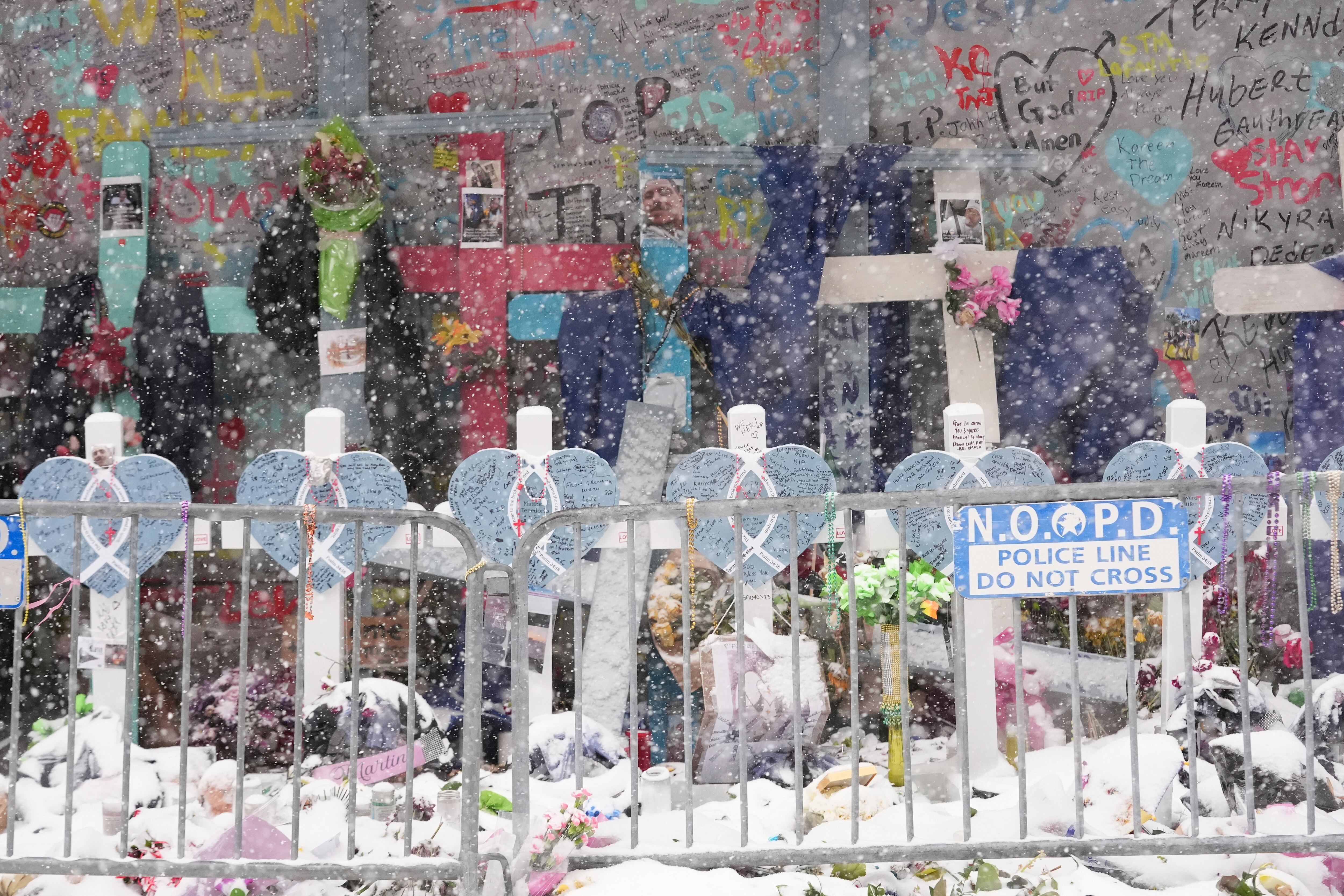 Snow falls as the memorial for the victims of a deadly truck attack on New Year's Day in the French Quarter is seen in New Orleans, Tuesday.