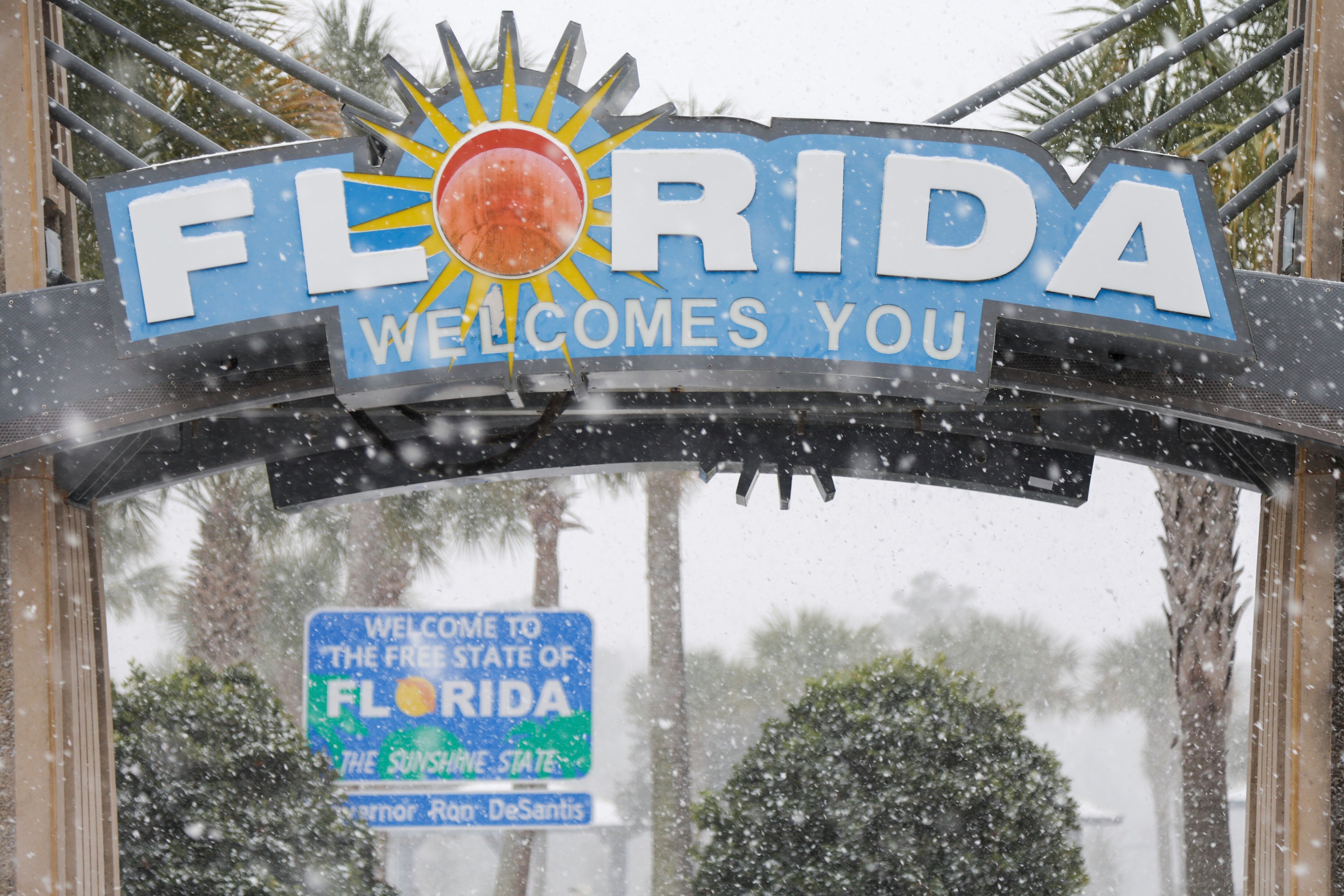 Heavy snow falls onto the Florida Welcome Center on Tuesday, in Pensacola, Fla.