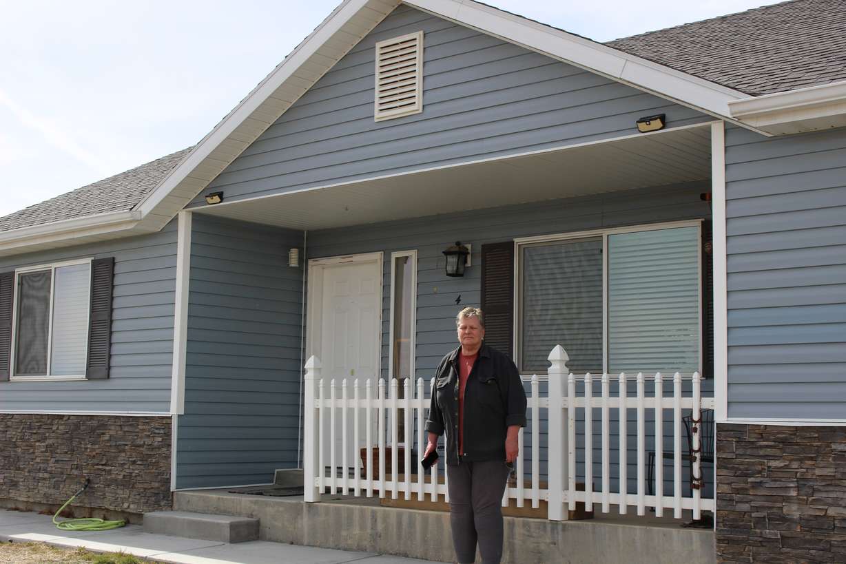 Beckie Gregg stands in front of her rented house in Tropic, Garfield County. She lost the ability to buy the home or earn the equity she put into it.