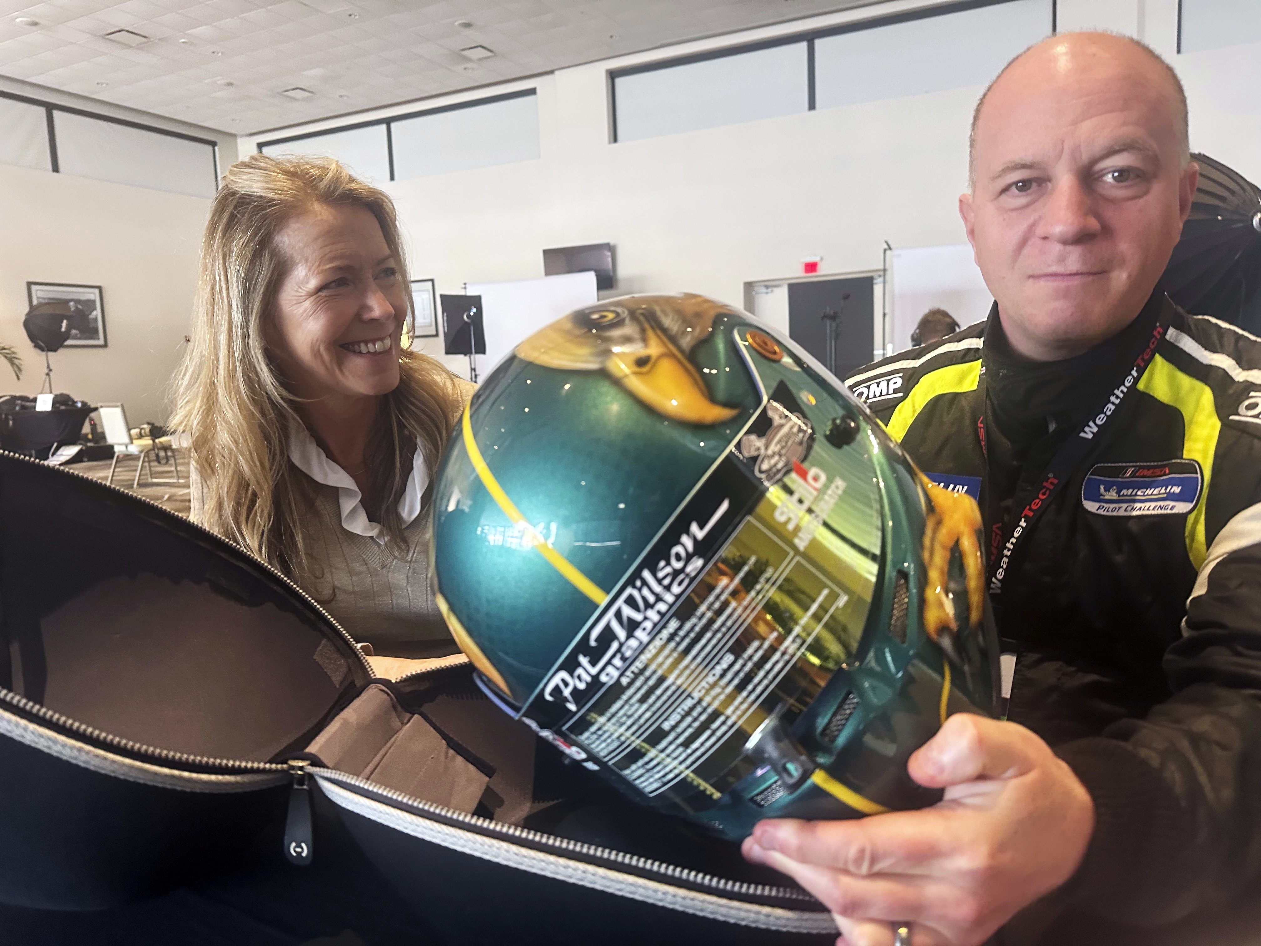 Tech executive and part-time racer Ben Sloss shows off the helmet designed by his wife Christine, Thursday, Jan. 16, 2025, at Daytona International Speedway in Daytona Beach, Fla., that he will wear in the Michelin Pilot Challenge race on Friday. The married couple are one of eight different teams that have family members racing together in Friday’s four-hour endurance race.