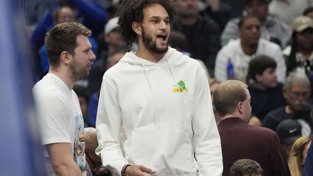 Injured Dallas Mavericks players Dereck Lively II, right, and Luka Doncic, left, look on from the bench during the first half of an NBA basketball game against the Oklahoma City Thunder, Friday, Jan. 17, 2025, in Dallas.