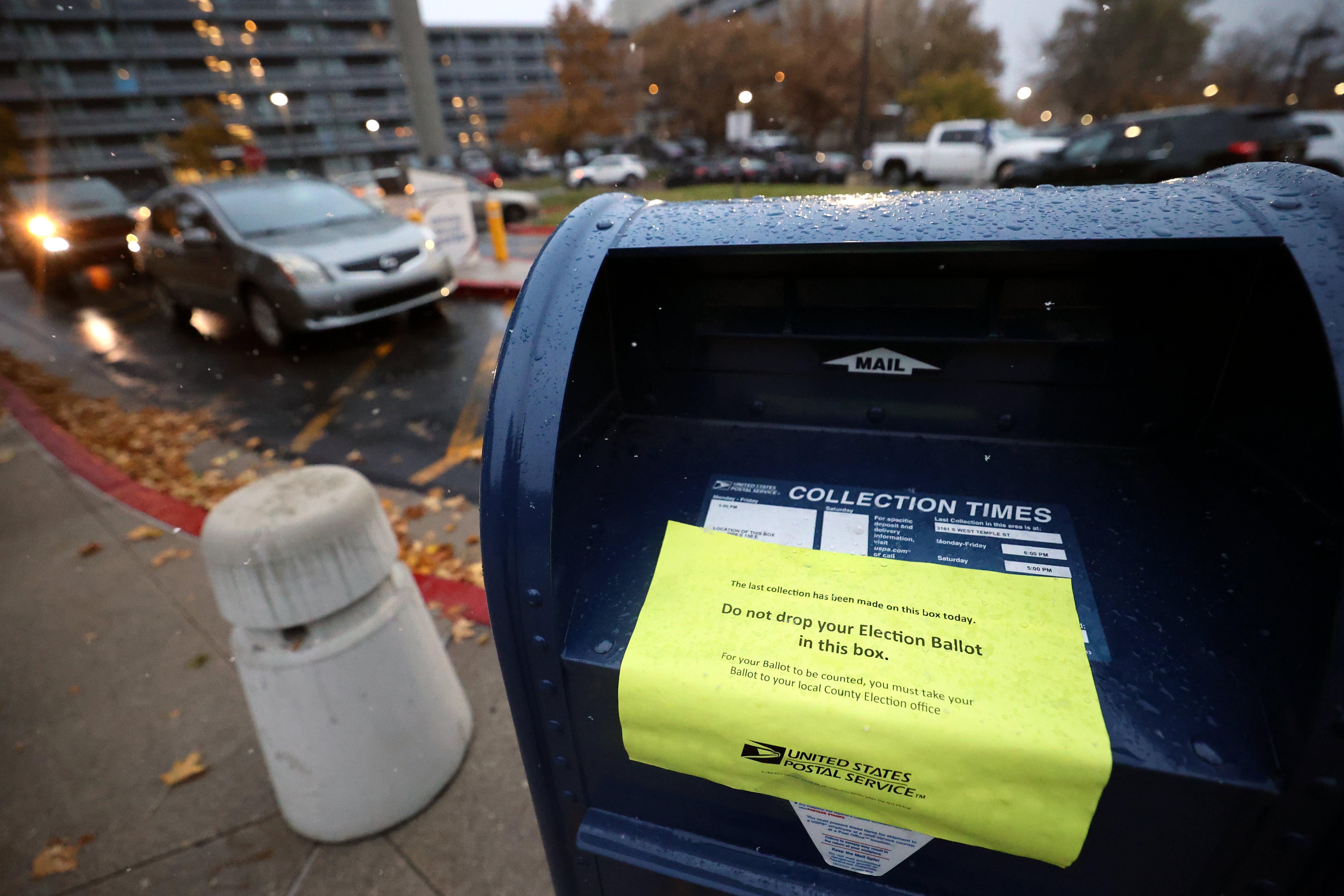 A sign is posted to stop people from dropping their ballots in the mailbox as vehicles line up for the official ballot drop boxes on Election Day outside of the Salt Lake County Government Center in Salt Lake City on Tuesday.