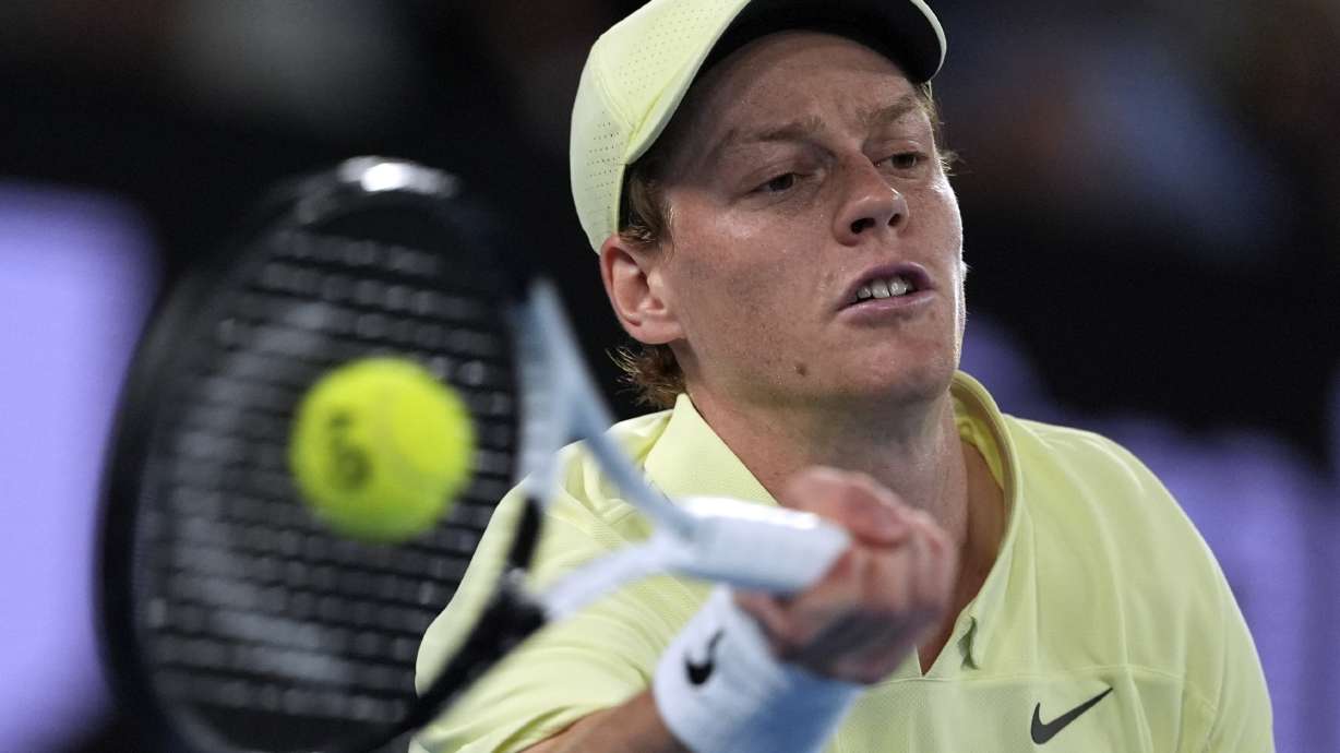Jannik Sinner of Italy plays a forehand return to Alex de Minaur of Australia during their quarterfinal match at the Australian Open tennis championship in Melbourne, Australia, Wednesday, Jan. 22, 2025.