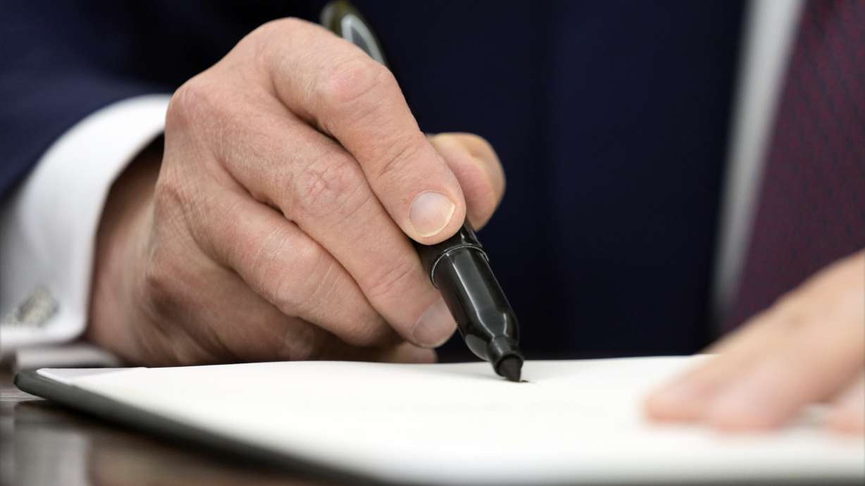 President Donald Trump signs an executive order in the Oval Office of the White House, Thursday, in Washington. Trump signed an executive order for innovation on artificial intelligence.
