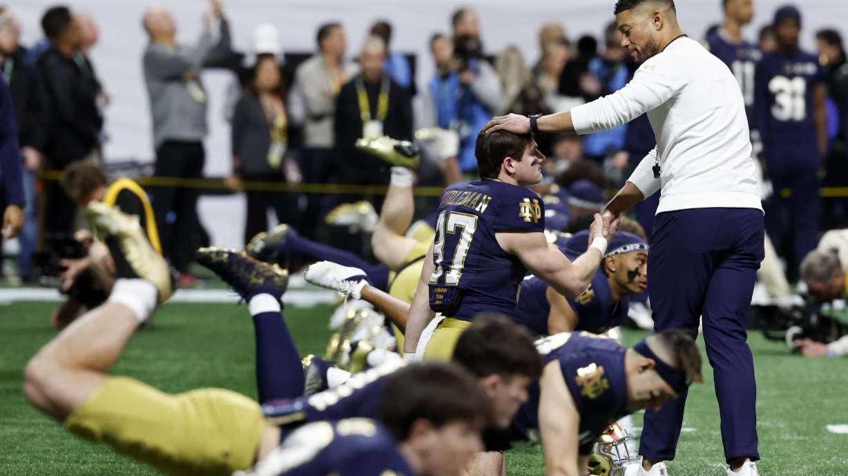 Notre Dame head coach Marcus Freeman greets players during warm ups before the College Football Playoff national championship game between Ohio State and Notre Dame Monday, Jan. 20, 2025, in Atlanta.