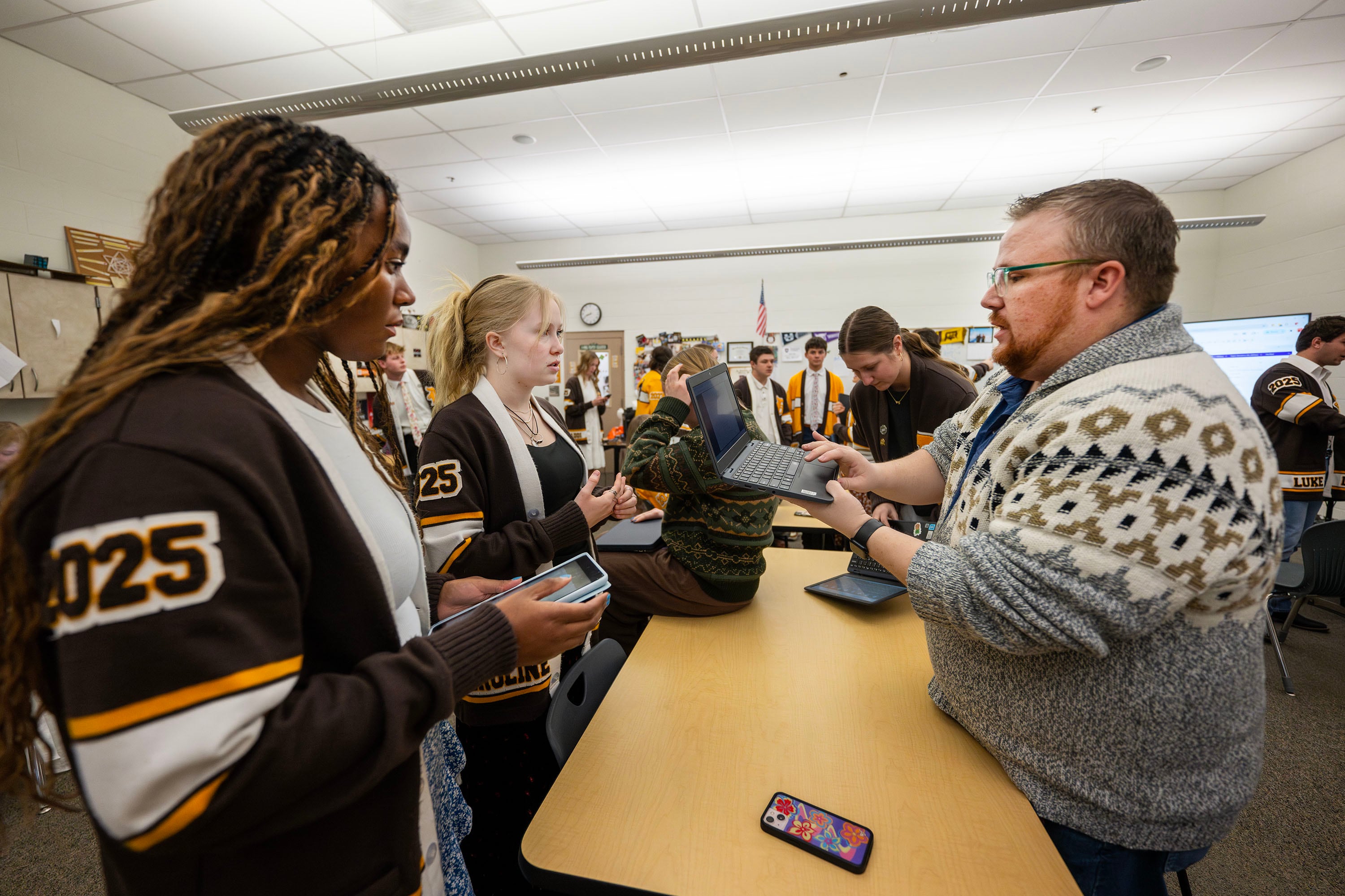 Davis High School student leaders Makenna Pearce and Caroline Taylor talk with advisor Erik Gunn as they and other officers work to verify names of former students who served in the armed forces over the years, on Jan. 17. They are working on making and installing a wall inside the school to display all the names.