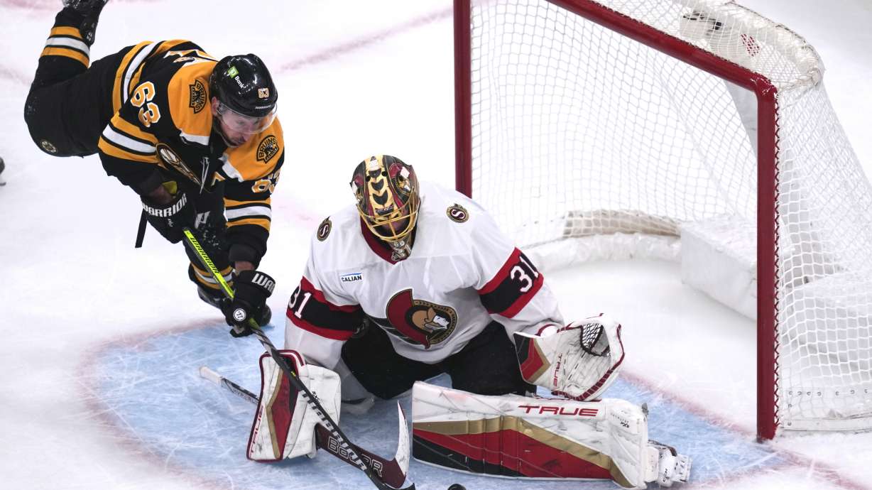 Boston Bruins left wing Brad Marchand (63) tries to poke the puck past Ottawa Senators goaltender Anton Forsberg (31) during the third period of an NHL hockey game, Thursday, Jan. 23, 2025, in Boston.