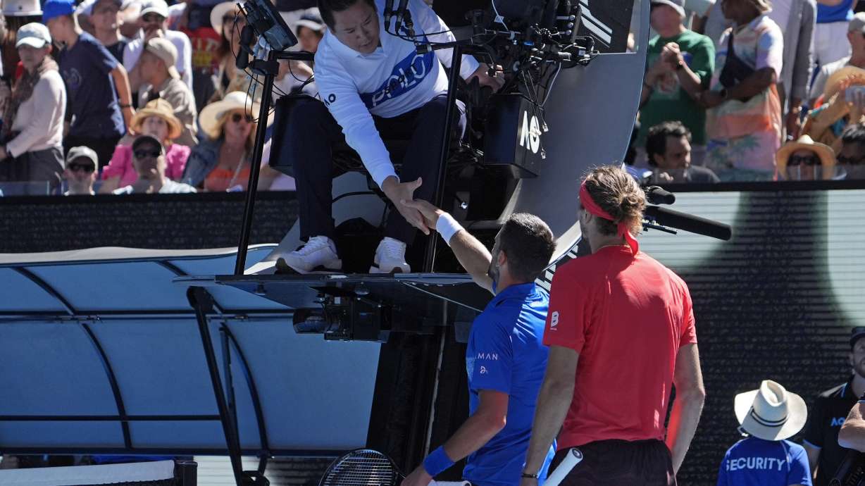 Novak Djokovic of Serbia shakes hands with chair umpire James Keothavong after retiring from his semifinal against Alexander Zverev of Germany at the Australian Open tennis championship in Melbourne, Australia, Friday, Jan. 24, 2025.