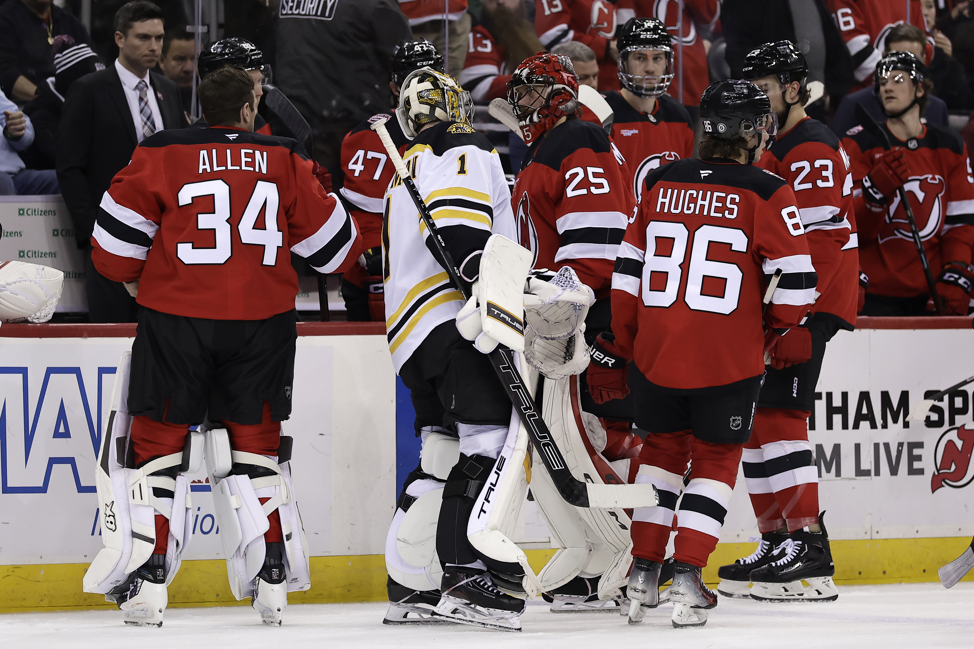 Boston Bruins goaltender Jeremy Swayman (1) checks on New Jersey Devils goaltender Jacob Markstrom (25) as he leaves the ice with an injury after a collision during the second period of an NHL hockey game Wednesday, Jan. 22, 2025, in Newark, N.J. New Jersey Devils goaltender Jake Allen (34) prepares to replace Markstrom.
