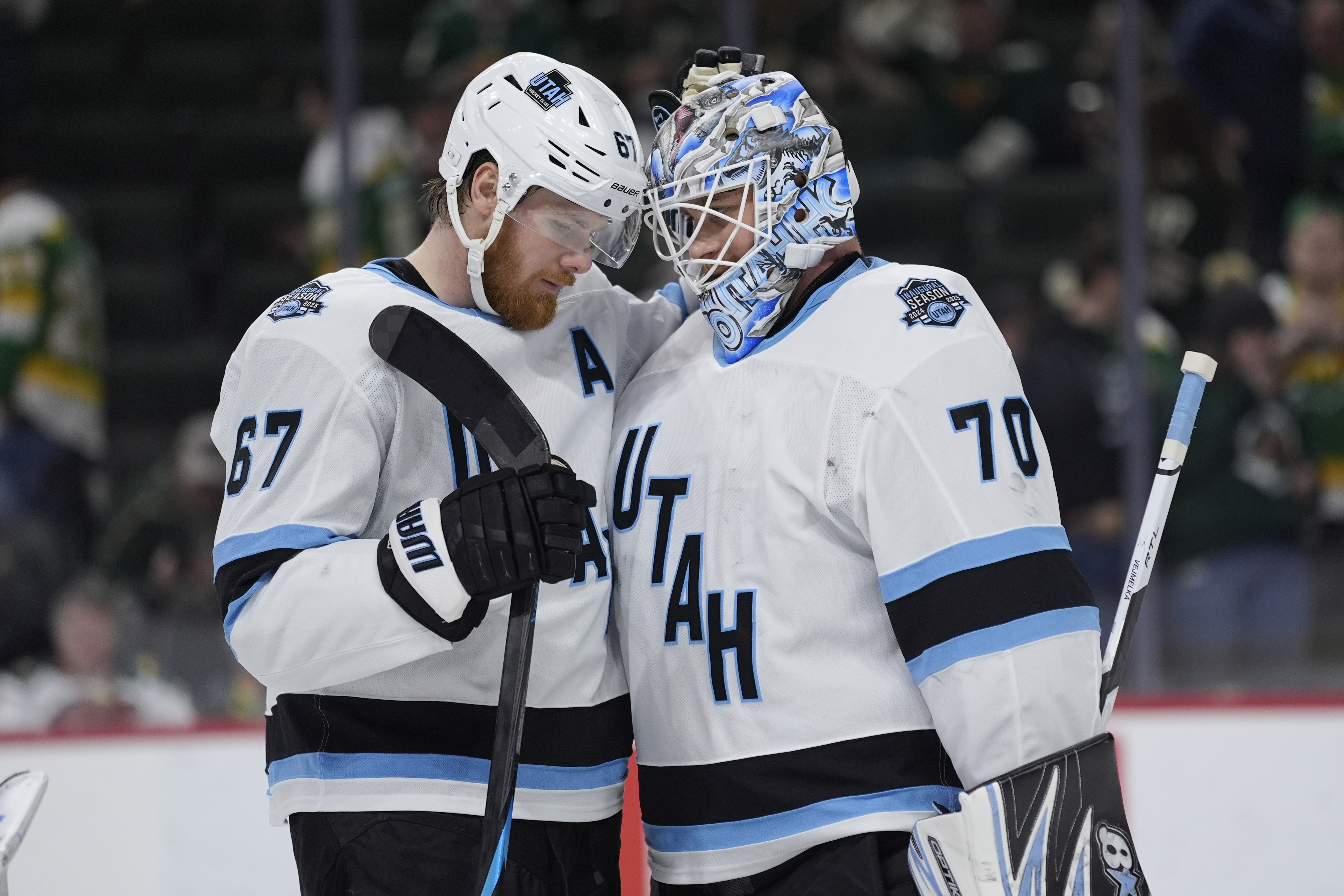 Utah Hockey Club left wing Lawson Crouse (67) and goaltender Karel Vejmelka (70) hug after a win over the Minnesota Wild of an NHL hockey game, Thursday, Jan. 23, 2025, in St. Paul, Minn.