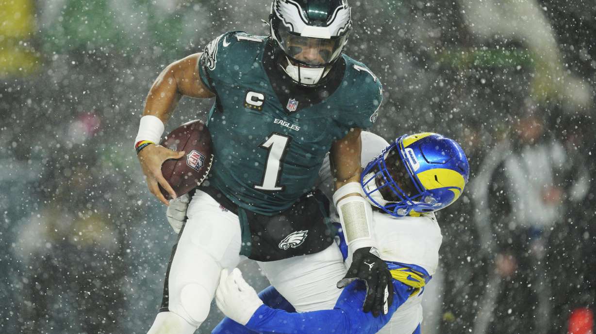 Los Angeles Rams defensive tackle Neville Gallimore (92) tackles Philadelphia Eagles quarterback Jalen Hurts (1) during the second half of an NFL football NFC divisional playoff game Sunday, Jan. 19, 2025, in Philadelphia.