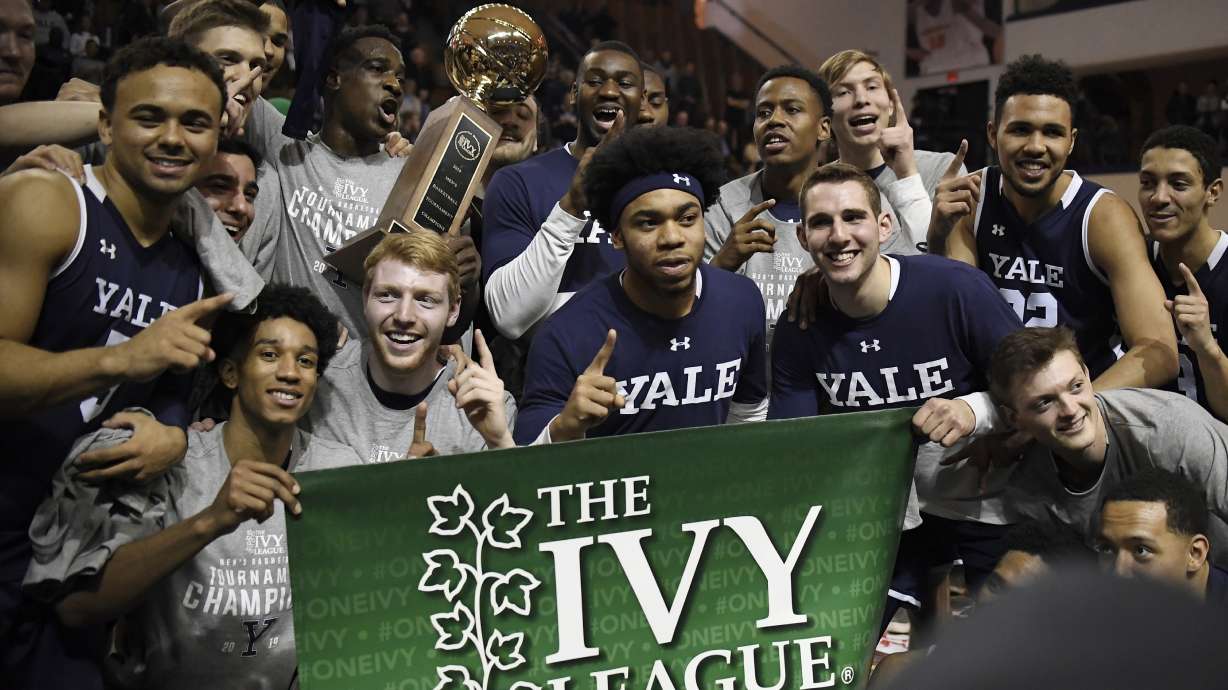 FILE - Yale players pose for a photograph with the championship trophy after defeating Harvard in an NCAA college basketball game for the Ivy League championship at Yale University in New Haven, Conn, March 17, 2019.