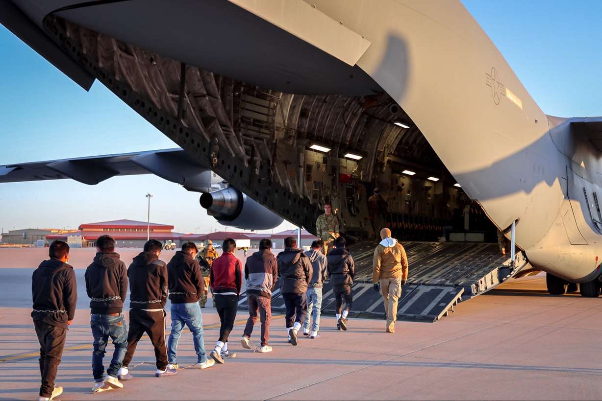 A contingent of immigrants board a U.S. military cargo airplane for deportation in a photo posted Friday by White House Press Secretary Karoline Leavitt.