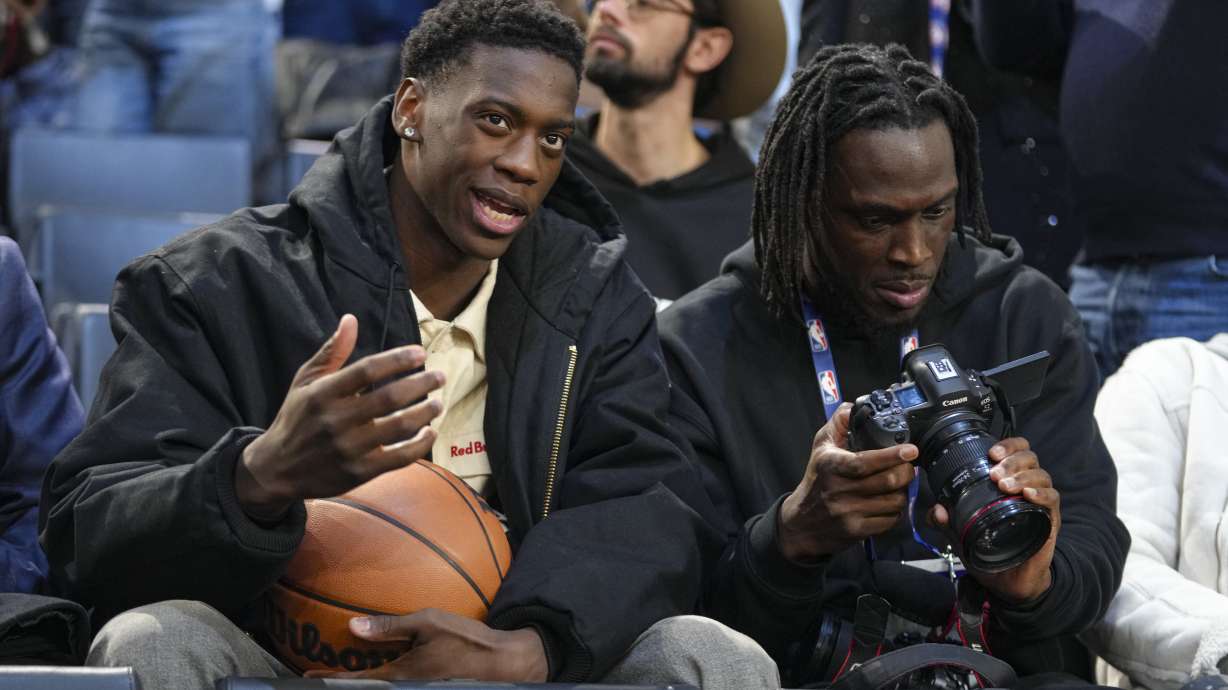 AJ Dybantsa, left, a BYU commit and projected 2026 NBA draft pick sits in the stand before a Paris Games 2025 NBA basketball game between the Indiana Pacers and the San Antonio Spurs in Paris, Saturday, Jan. 25, 2025.