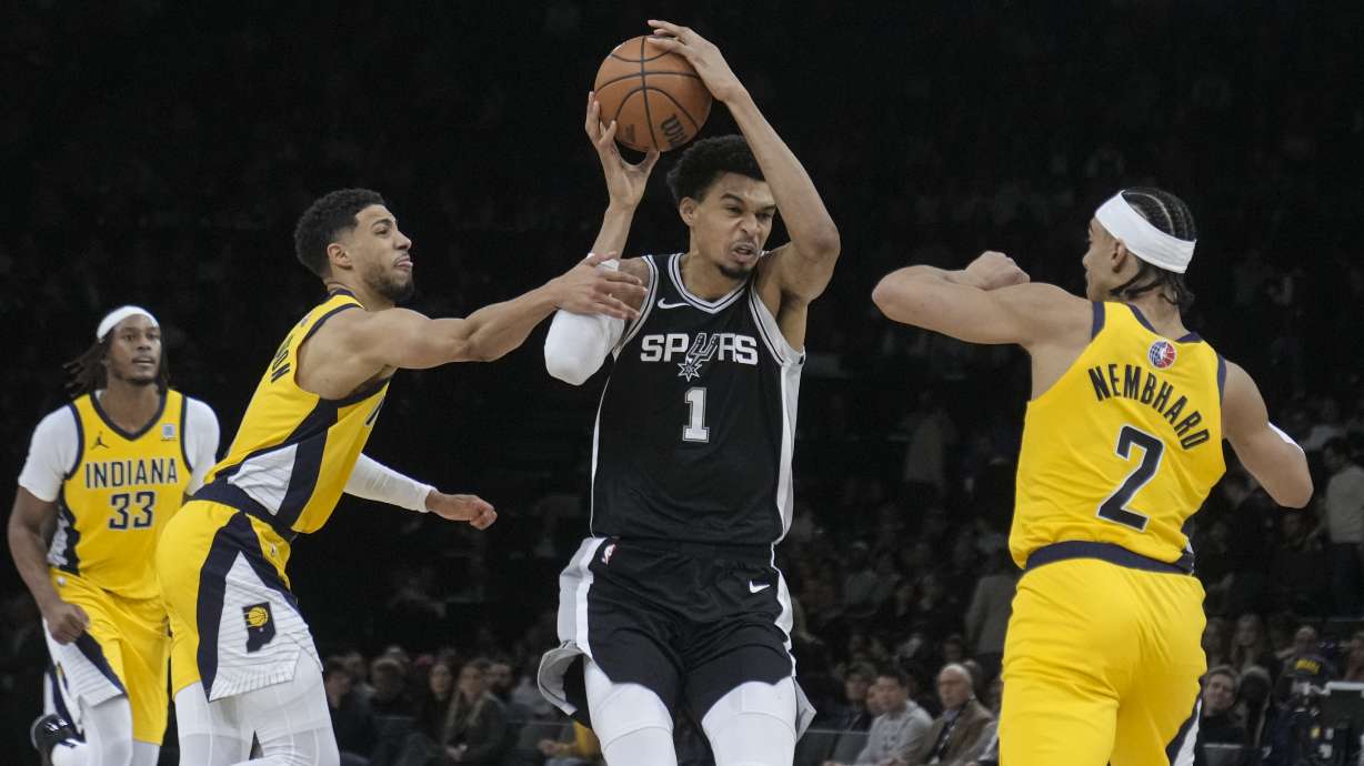 San Antonio Spurs center Victor Wembanyama (1) looks to shoot between Indiana Pacers guard Tyrese Haliburton (0) and guard Andrew Nembhard (2) during the second half of a Paris Games 2025 NBA basketball game in Paris, Saturday, Jan. 25, 2025.