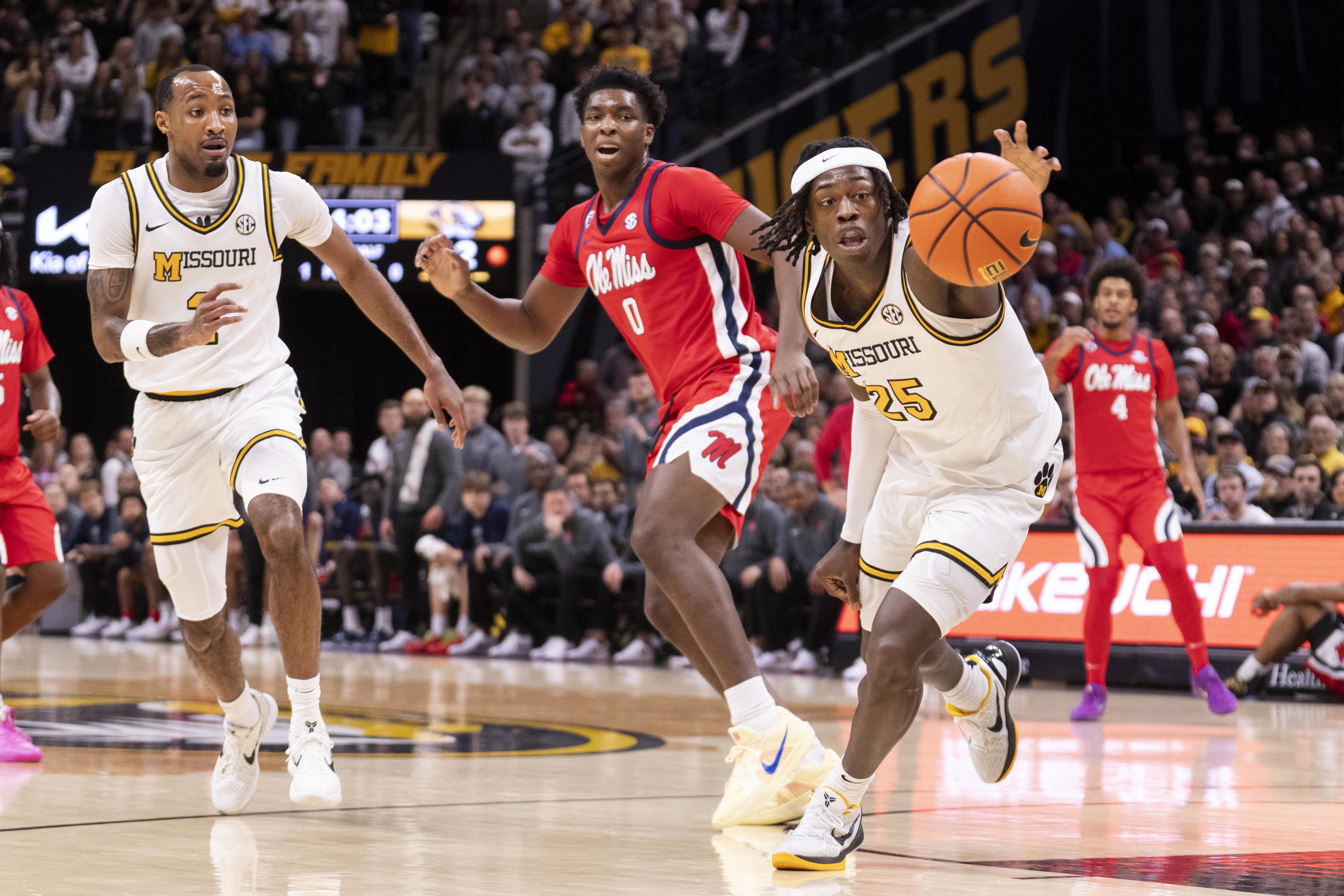 Missouri's Mark Mitchell, right, grabs a loose ball in front of Mississippi's Malik Dia (0) and Tamar Bates, left, during the first half of an NCAA college basketball game Saturday, Jan. 25, 2025, in Columbia, Mo.