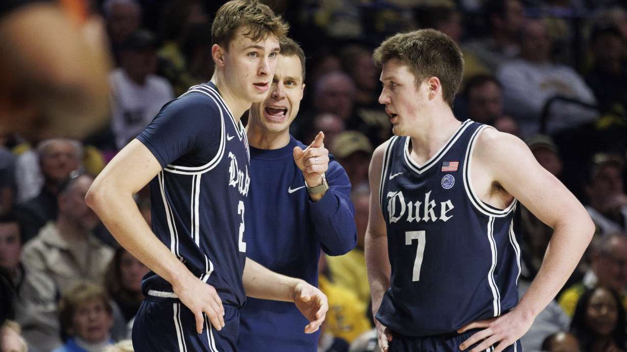 Duke head coach Jon Scheyer, middle, speaks to Cooper Flagg (2) and Kon Knueppel (7) during the second half of an NCAA college basketball game against Wake Forest in Winston-Salem, N.C., Saturday, Jan. 25, 2025.