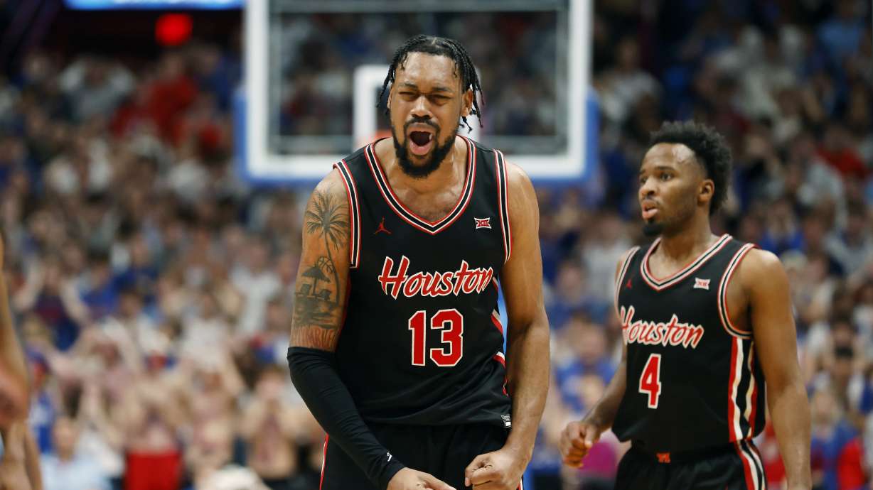 Houston forward J'Wan Roberts (13) reacts after scoring the go-ahead basket next to guard L.J. Cryer (4) during double overtime against Kansas in an NCAA college basketball game, Saturday, Jan. 25, 2025, in Lawrence, Kan.
