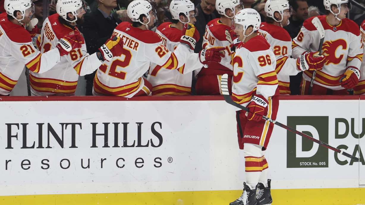 Calgary Flames left wing Andrei Kuzmenko (96) celebrates at the bench after scoring a goal during the first period of an NHL hockey game against the Minnesota Wild, Saturday, Jan. 25, 2025, in St. Paul, Minn.