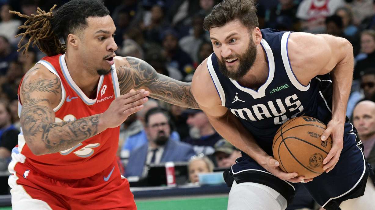 Dallas Mavericks forward Maxi Kleber, right, handles the ball against Memphis Grizzlies forward Brandon Clarke, left, in the second half of an NBA basketball game Monday, Jan. 6, 2025, in Memphis, Tenn.