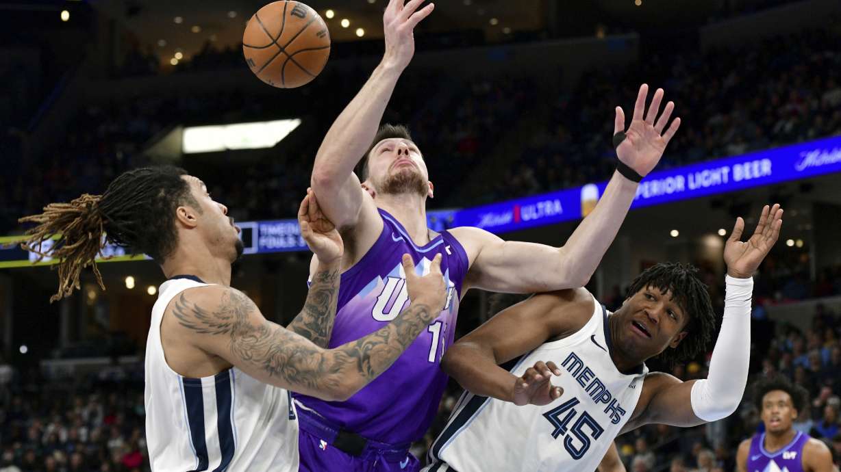 Utah Jazz forward Drew Eubanks struggles for control of the ball between Memphis Grizzlies forwards GG Jackson II (45) and Brandon Clarke, left, in the first half of an NBA basketball game, Saturday, Jan. 25, 2025, in Memphis, Tenn.