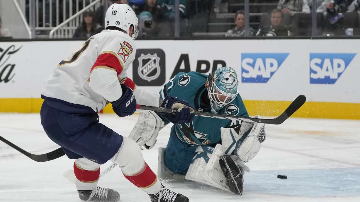 Florida Panthers left wing A.J. Greer, left, scores against San Jose Sharks goaltender Alexandar Georgiev during the second period of an NHL hockey game in San Jose, Calif., Saturday, Jan. 25, 2025.