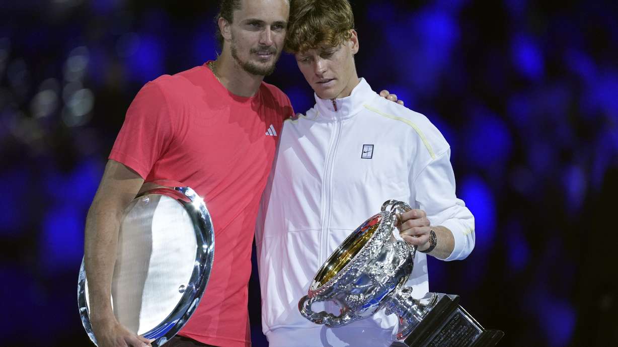 Jannik Sinner, right, of Italy holds the Norman Brookes Challenge Cup after defeating Alexander Zverev of Germany in the men's singles final at the Australian Open tennis championship in Melbourne, Australia, Sunday, Jan. 26, 2025.