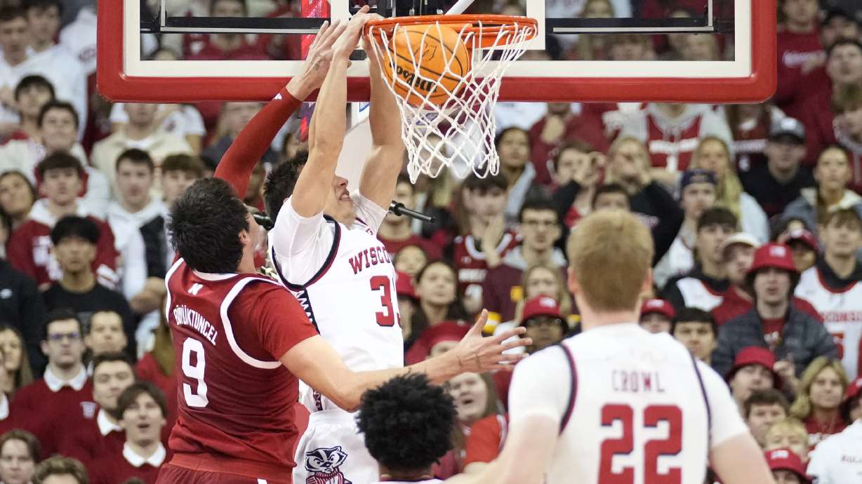 Wisconsin guard Jack Janicki, center, dunks the ball against Nebraska forward Berke Buyuktuncel (9) during the first half of an NCAA college basketball game Sunday, Jan. 26, 2025, in Madison, Wis.