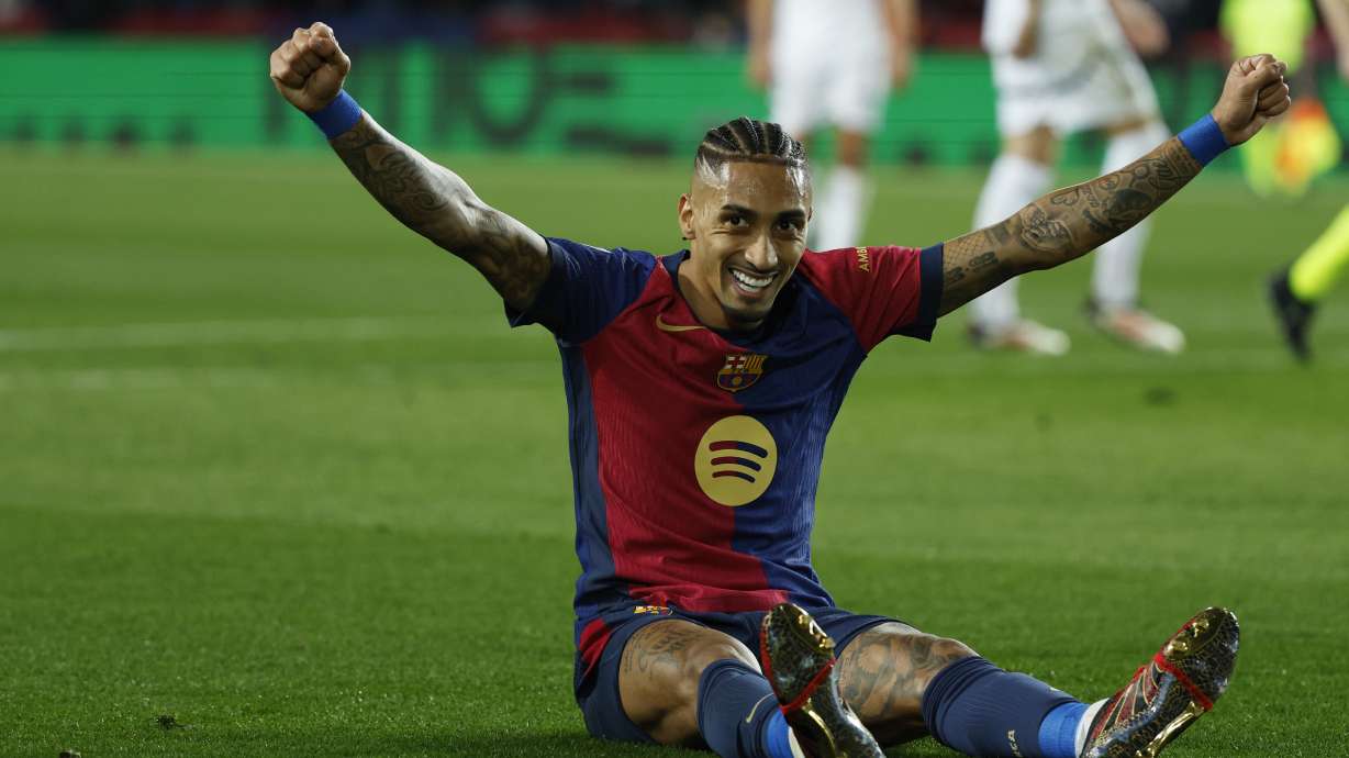 Barcelona's Raphinha celebrates after Fermin Lopez, not in the picture, scored his side's fifth goal during the Spanish La Liga soccer match between Barcelona and Valencia at the Lluis Companys Olympic Stadium in Barcelona, Spain, Sunday, Jan. 26, 2025.