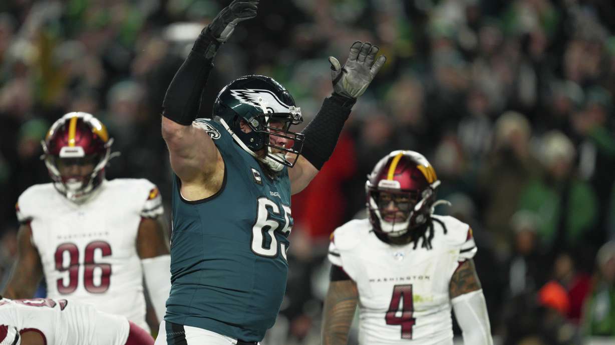 Philadelphia Eagles offensive tackle Lane Johnson (65) celebrates a touchdown by quarterback Jalen Hurts during the second half of the NFC Championship NFL football game against the Washington Commanders, Sunday, Jan. 26, 2025, in Philadelphia.