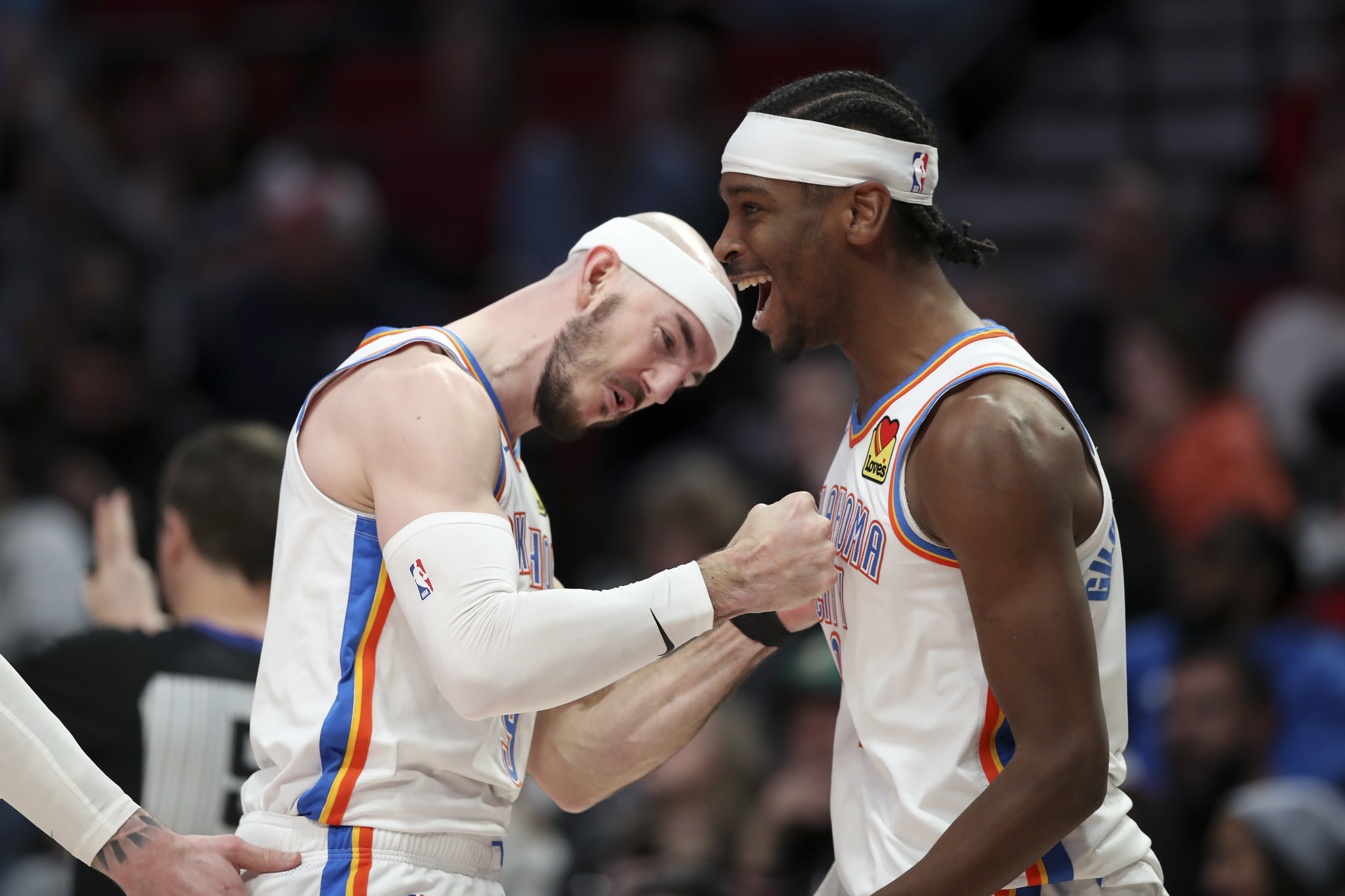 Oklahoma City Thunder guards Alex Caruso, left, and Shai Gilgeous-Alexander, right, react after a call in their favor during the second half of an NBA basketball game against the Portland Trail Blazers, Sunday, Jan. 26, 2025, in Portland, Ore.