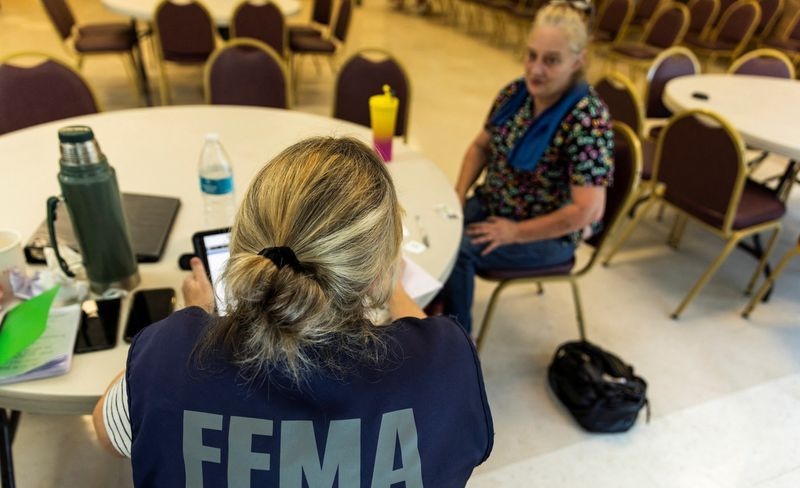A Federal Emergency Management Agency worker serves a person affected by Hurricane Helene, in Marion, N.C., Oct. 5. Trump on Sunday issued an executive order establishing a review council to evaluate the agency.