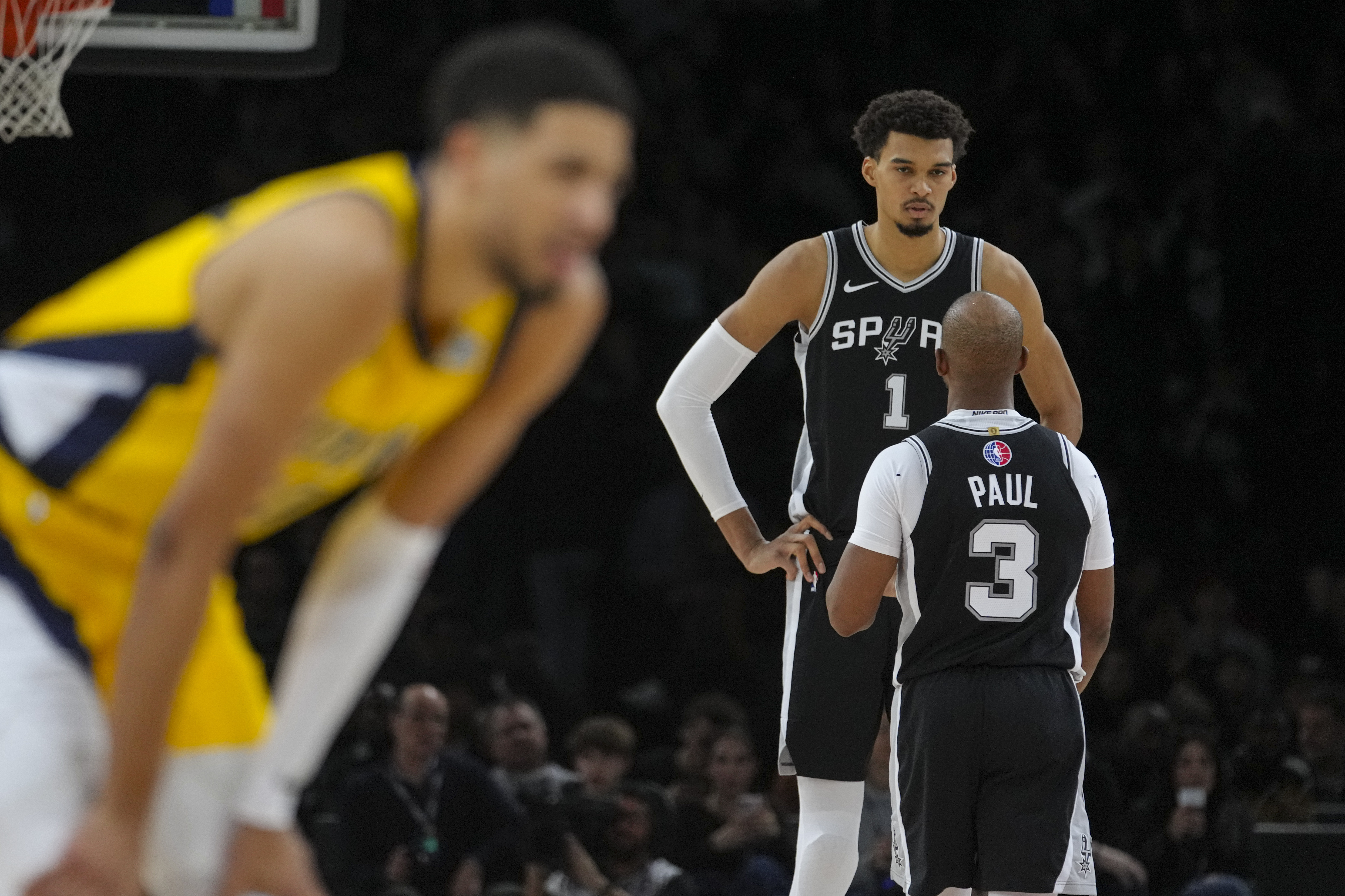 San Antonio Spurs center Victor Wembanyama (1) talks with guard Chris Paul (3) during the second half of a Paris Games 2025 NBA basketball game against the Indiana Pacers in Paris, Saturday, Jan. 25, 2025.