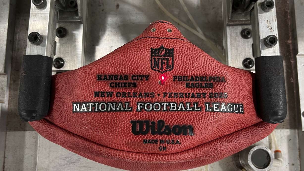 A machine imprints the names of the Philadelphia Eagles and the Kansas City Chiefs onto a football for the upcoming Super Bowl matchup at the Wilson Sporting Goods football factory, Monday, January 27, 2025, in Ada, Ohio.