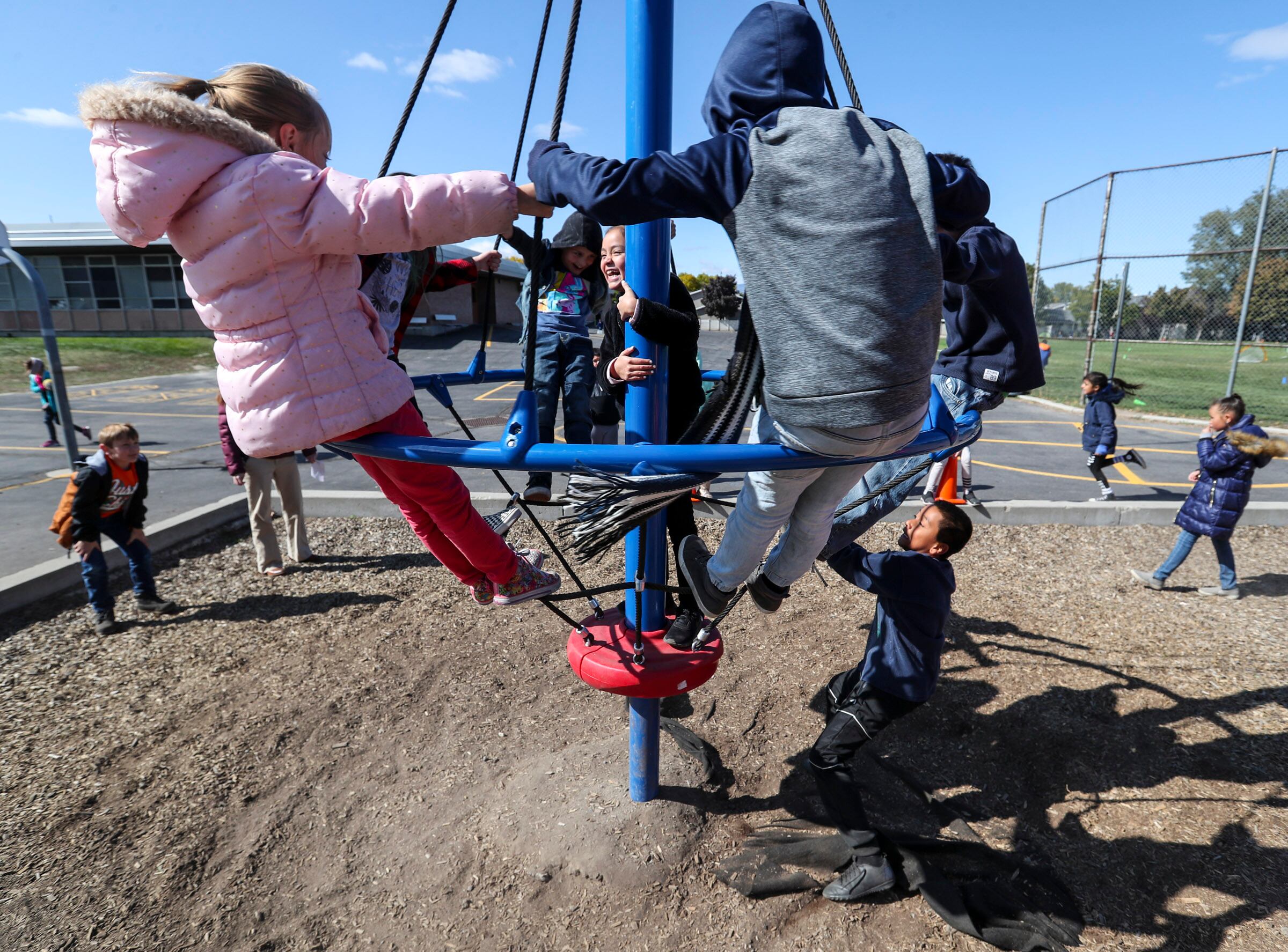 Third graders spin around on a new piece of playground equipment during lunch recess at Liberty Elementary School in Murray on Oct. 10, 2019. A state lawmaker is advocating for more unstructured playtime for children.