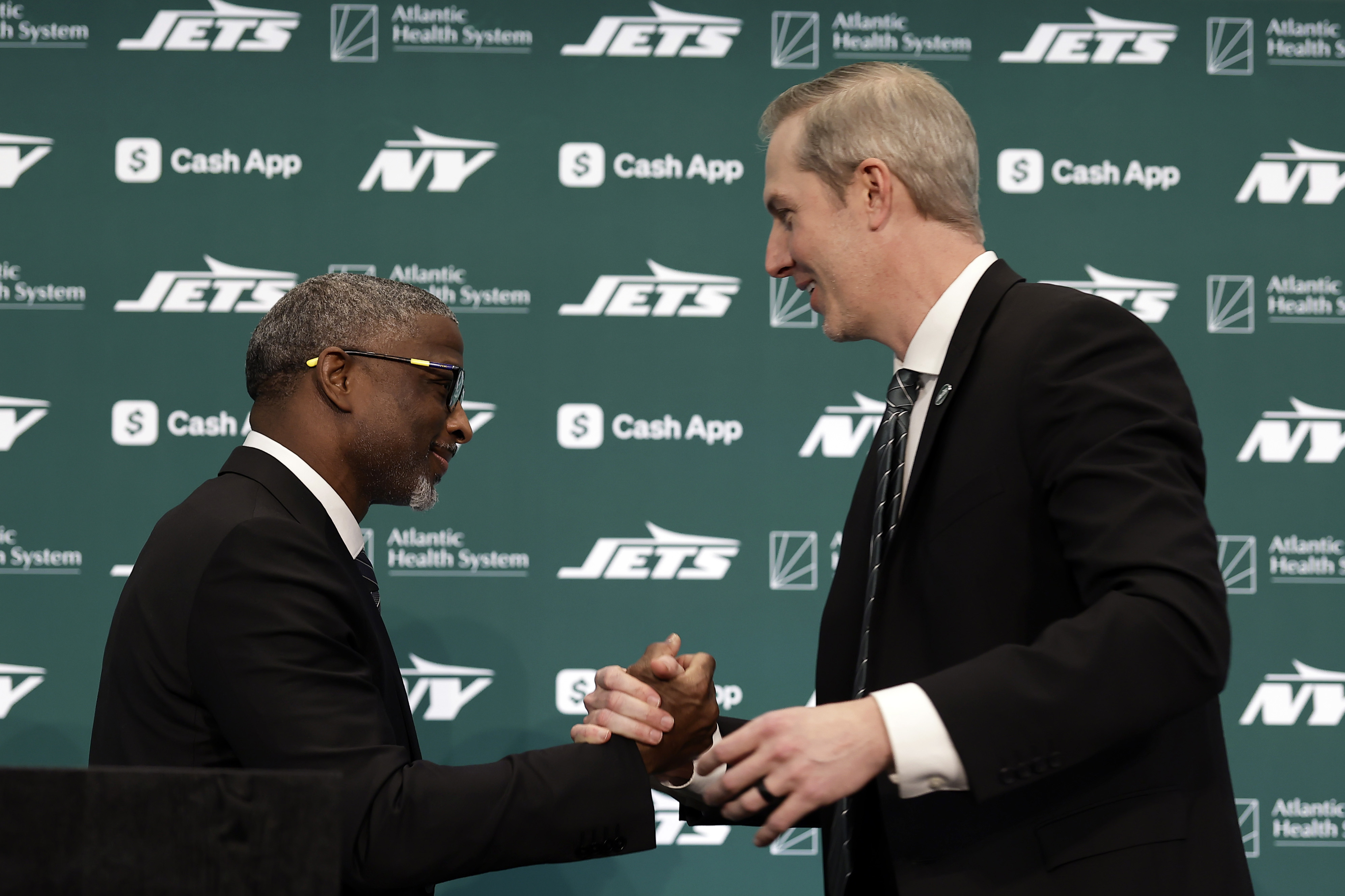 New York Jets new head coach Aaron Glenn, left, shakes hands with general manager Darren Mougey during a press conference at the NFL football team's training facility on Monday, Jan. 27, 2025, in Florham Park, N.J. 