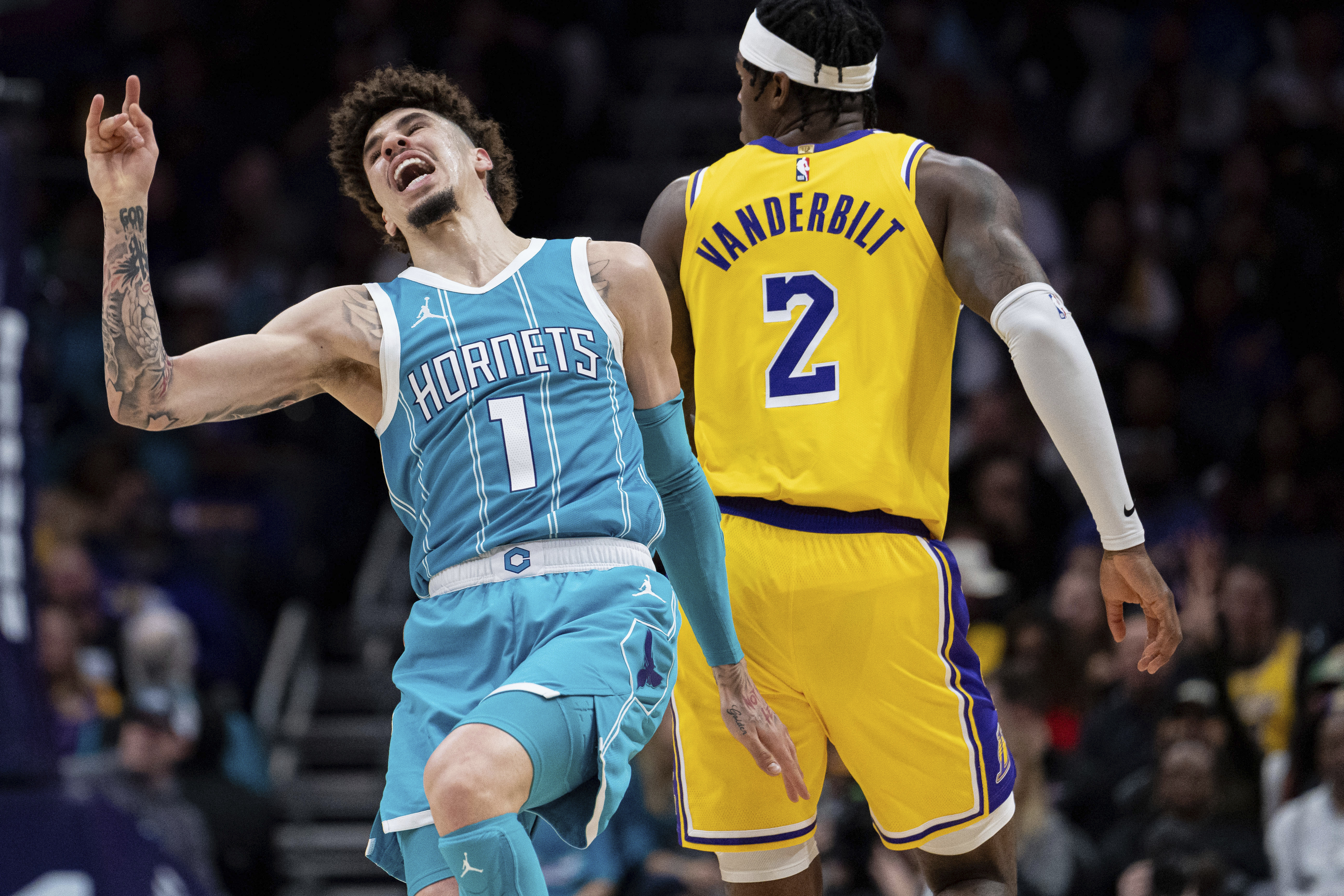 Charlotte Hornets guard LaMelo Ball (1) reacts as he trips over Los Angeles Lakers forward Jarred Vanderbilt (2) during the first half of an NBA basketball game Monday, Jan. 27, 2025, in Charlotte, N.C. 