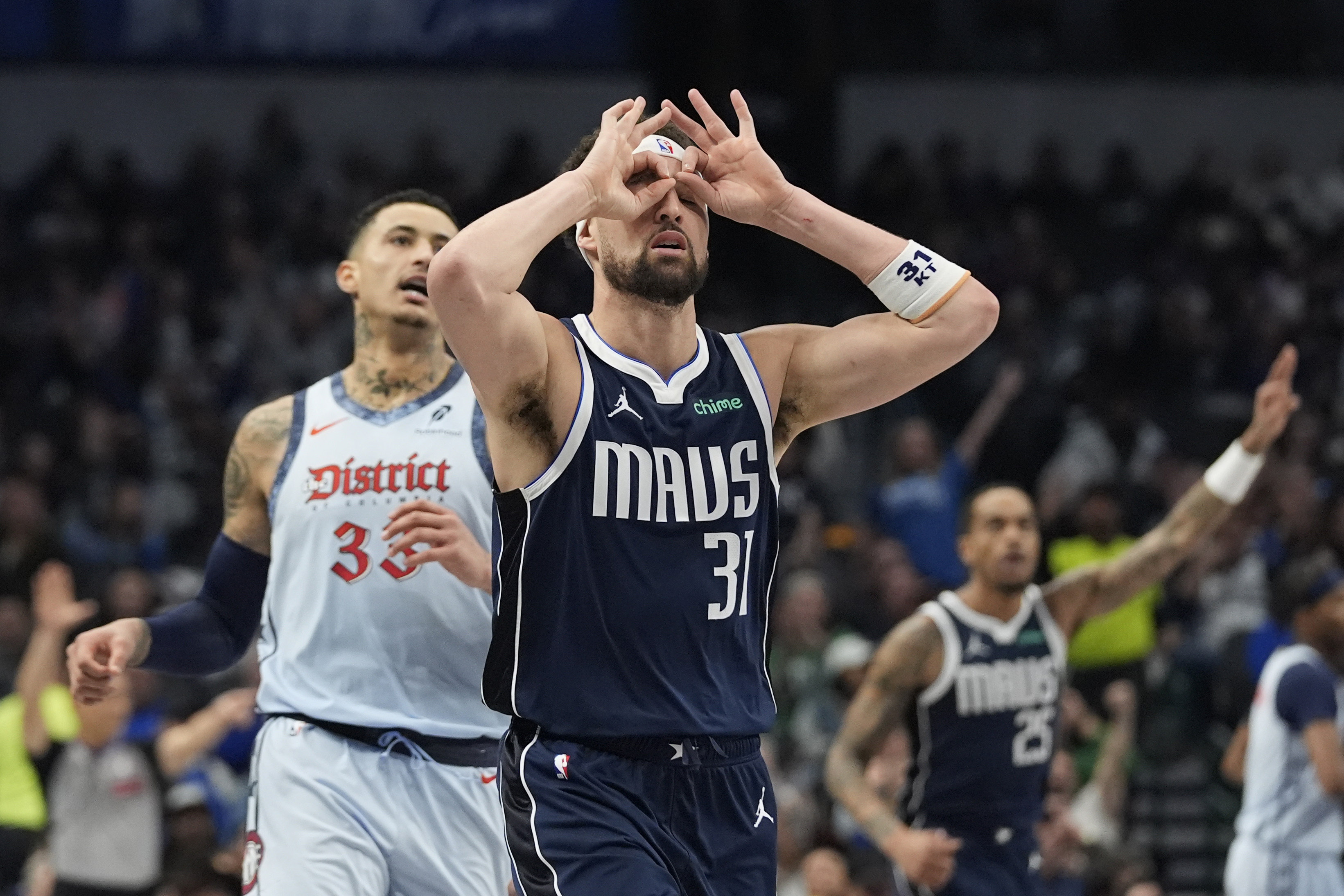 Dallas Mavericks guard Klay Thompson (31) gestures after scoring a 3-point basket against Washington Wizards forward Kyle Kuzma, left, during the first half of an NBA basketball game Monday, Jan. 27, 2025, in Dallas. 