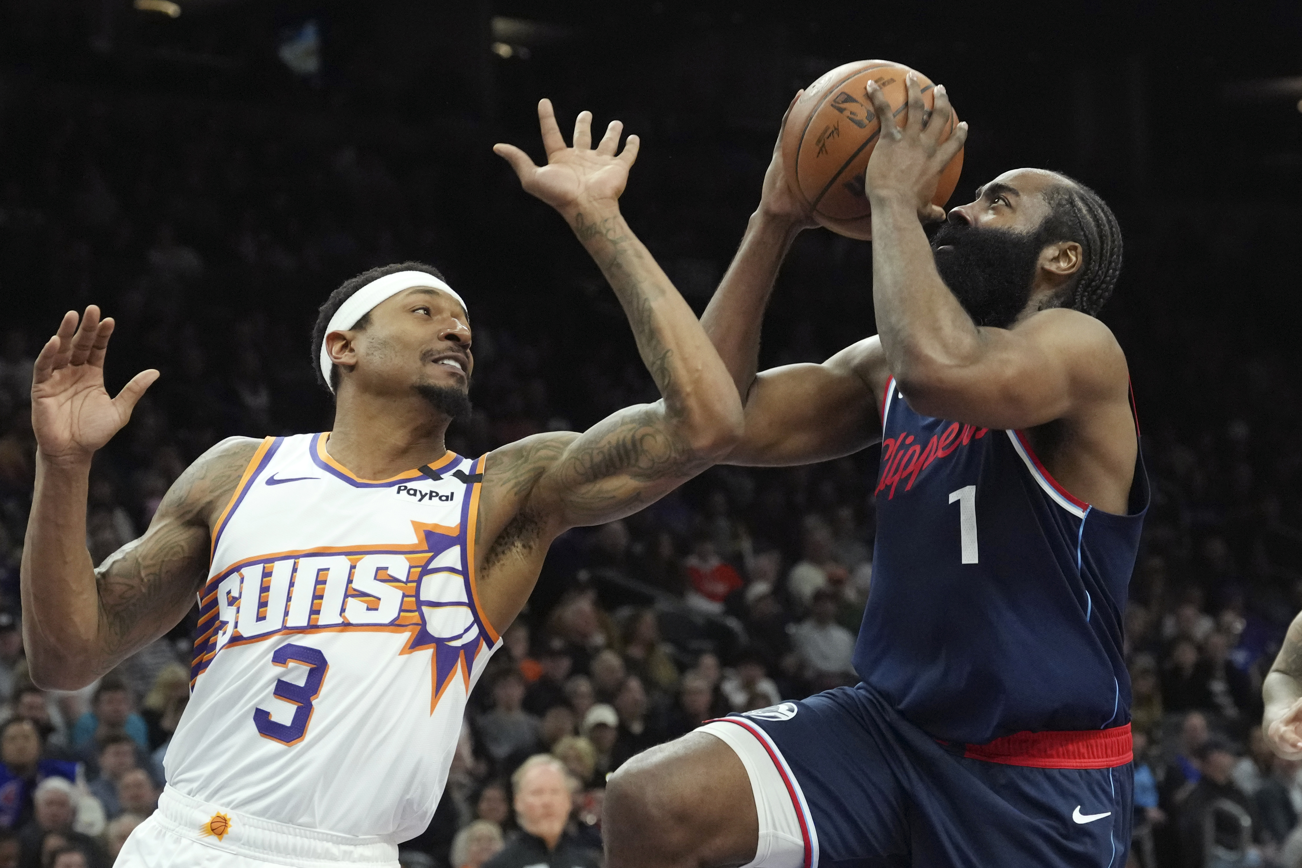 Los Angeles Clippers guard James Harden (1) drives to the basket against Phoenix Suns guard Bradley Beal (3) during the first half of an NBA basketball game Monday, Jan. 27, 2025, in Phoenix. 