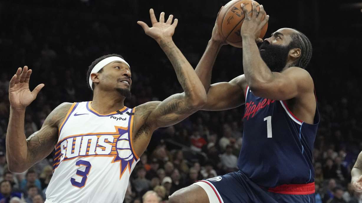 Los Angeles Clippers guard James Harden (1) drives to the basket against Phoenix Suns guard Bradley Beal (3) during the first half of an NBA basketball game Monday, Jan. 27, 2025, in Phoenix.