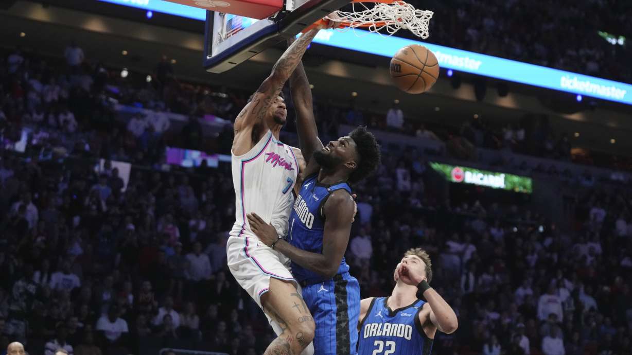 Miami Heat center Kel'el Ware, left, dunks over Orlando Magic forward Jonathan Isaac, center, during the second half of an NBA basketball game, Monday, Jan. 27, 2025, in Miami.