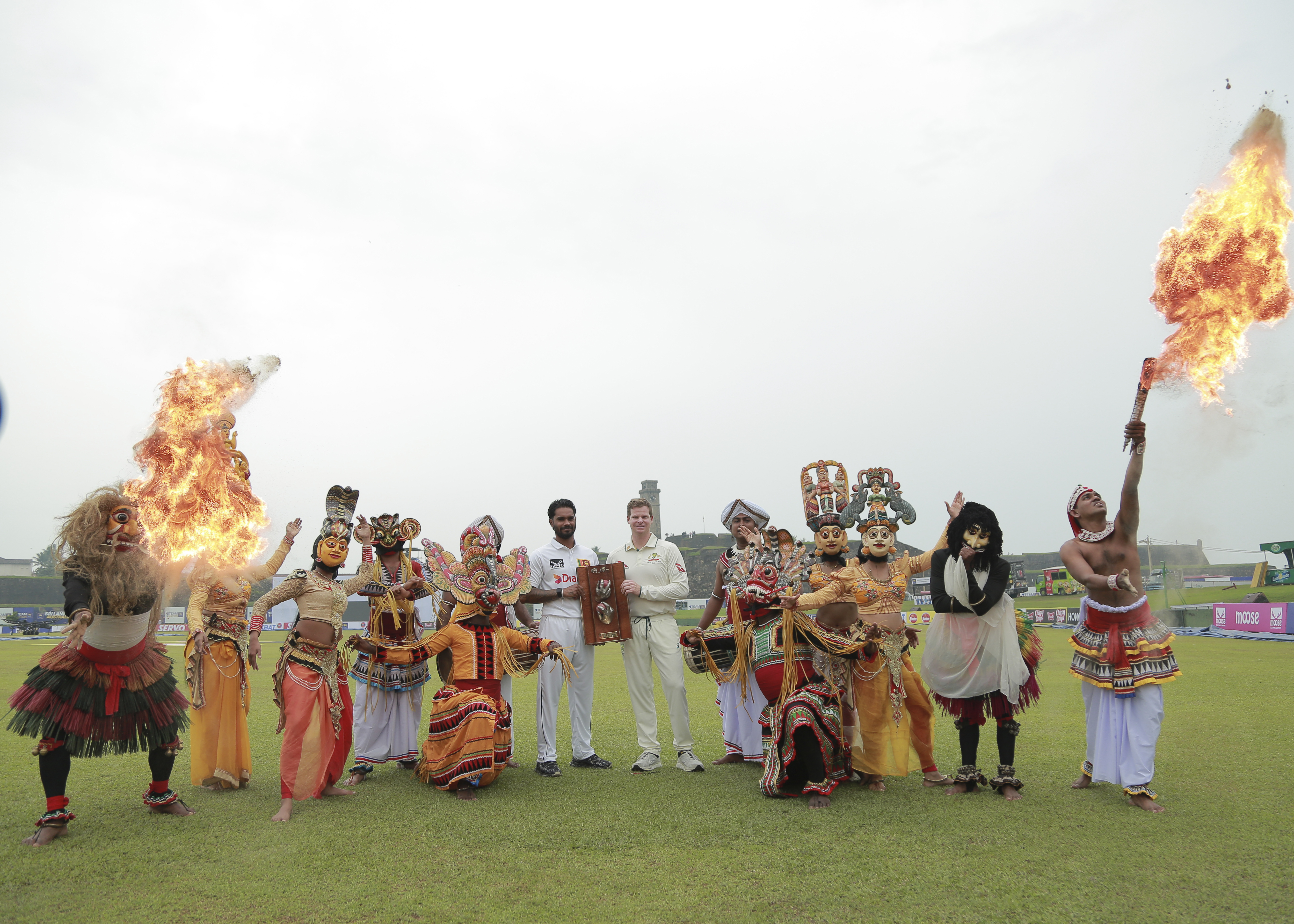 Sri Lankan traditional dancers perform asSri Lanka's test cricket captain Dhananjaya de Silva, center left, and his Australian counterpart Steve Smith pose with the Warne–Muralitharan trophy ahead of their two test match series in Galle, Sri Lanka, Tuesday, Jan. 28, 2025. 
