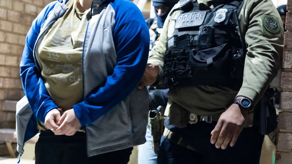 U.S. Immigration and Customs Enforcement officers detain a person, left, Jan. 27, in Silver Spring, Md. A group of Quakers is challenging the Trump administration's immigration policy on the grounds of religious liberty.